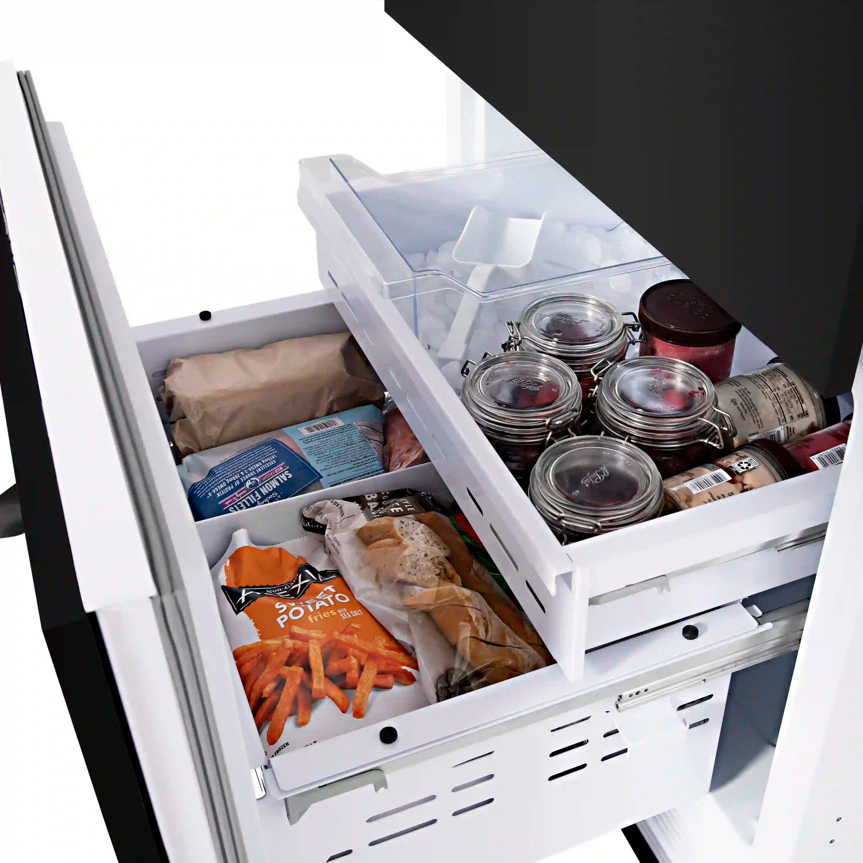 Pull-out bottom freezer drawer open with jars, bottles, and frozen food