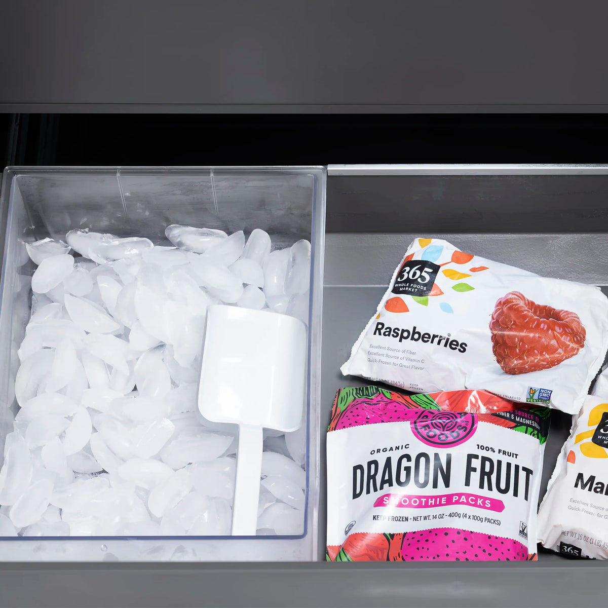 Refrigerator freezer drawer with ice cubes and wrapped fruit smoothie packs