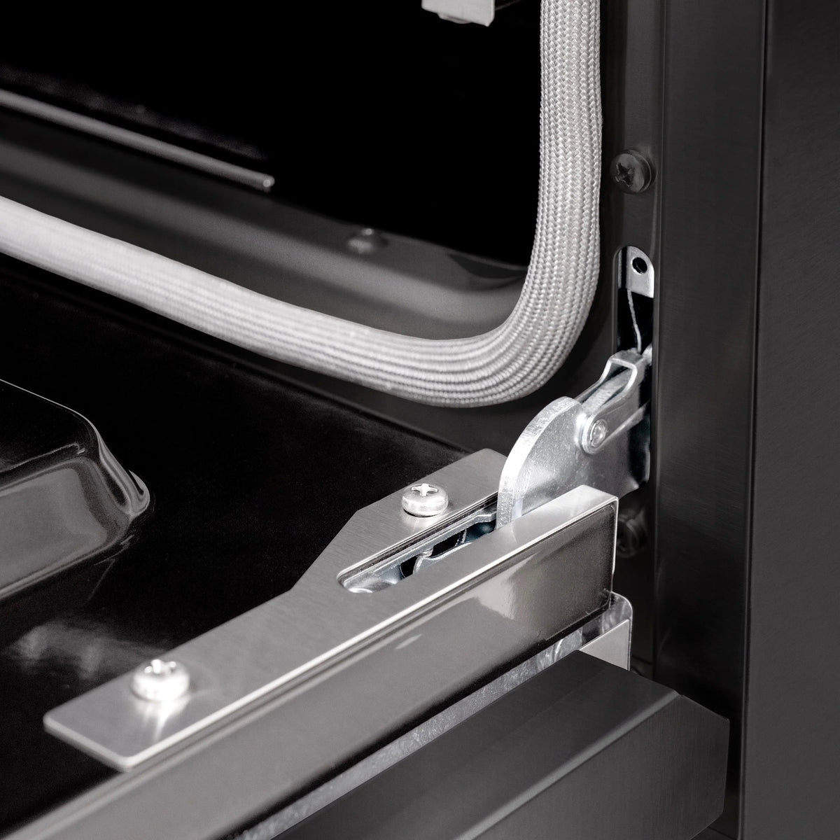 Black oven door hinge bracket with secured flexible hose connection