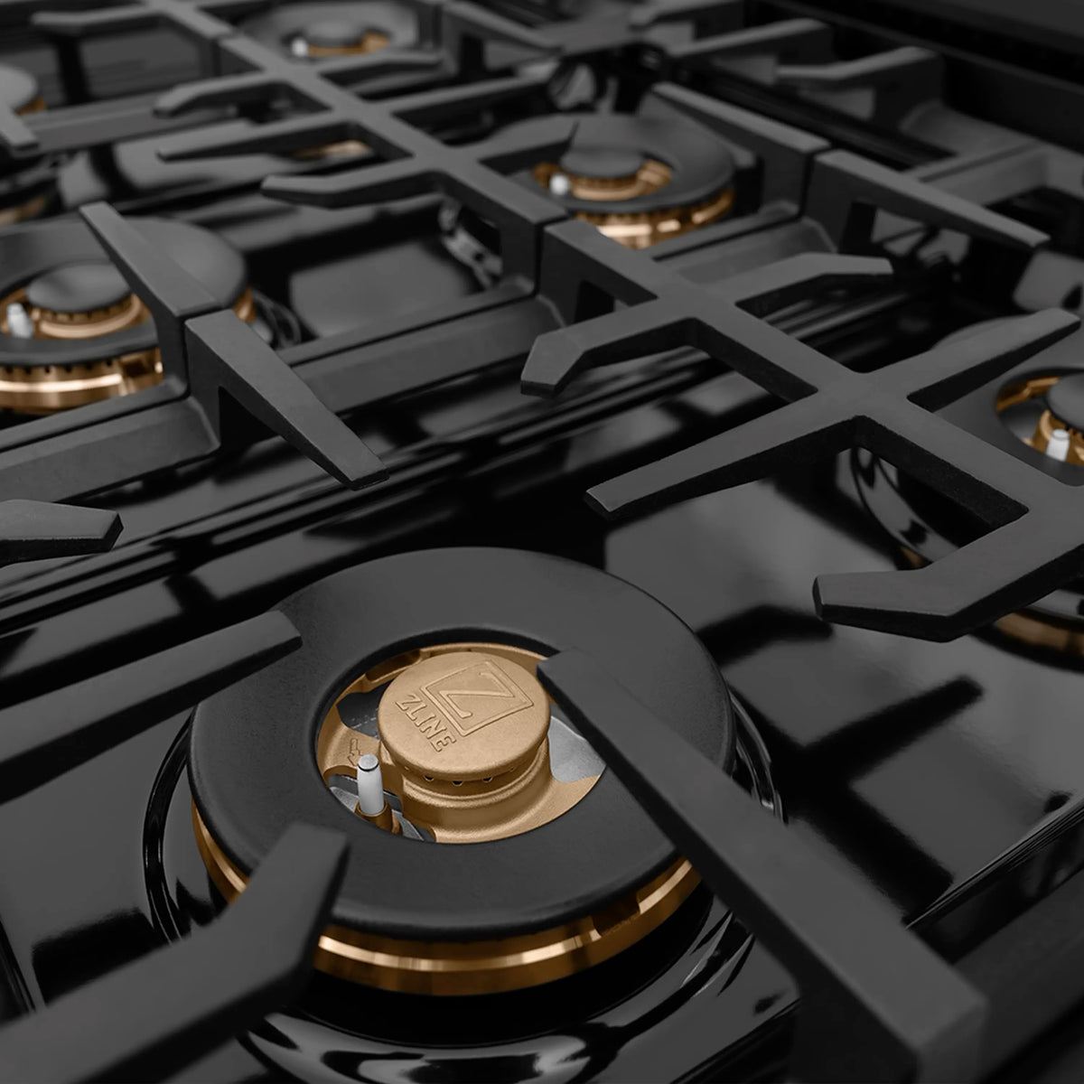 Stainless gas cooktop with multiple cast-iron grates and brass burner rings