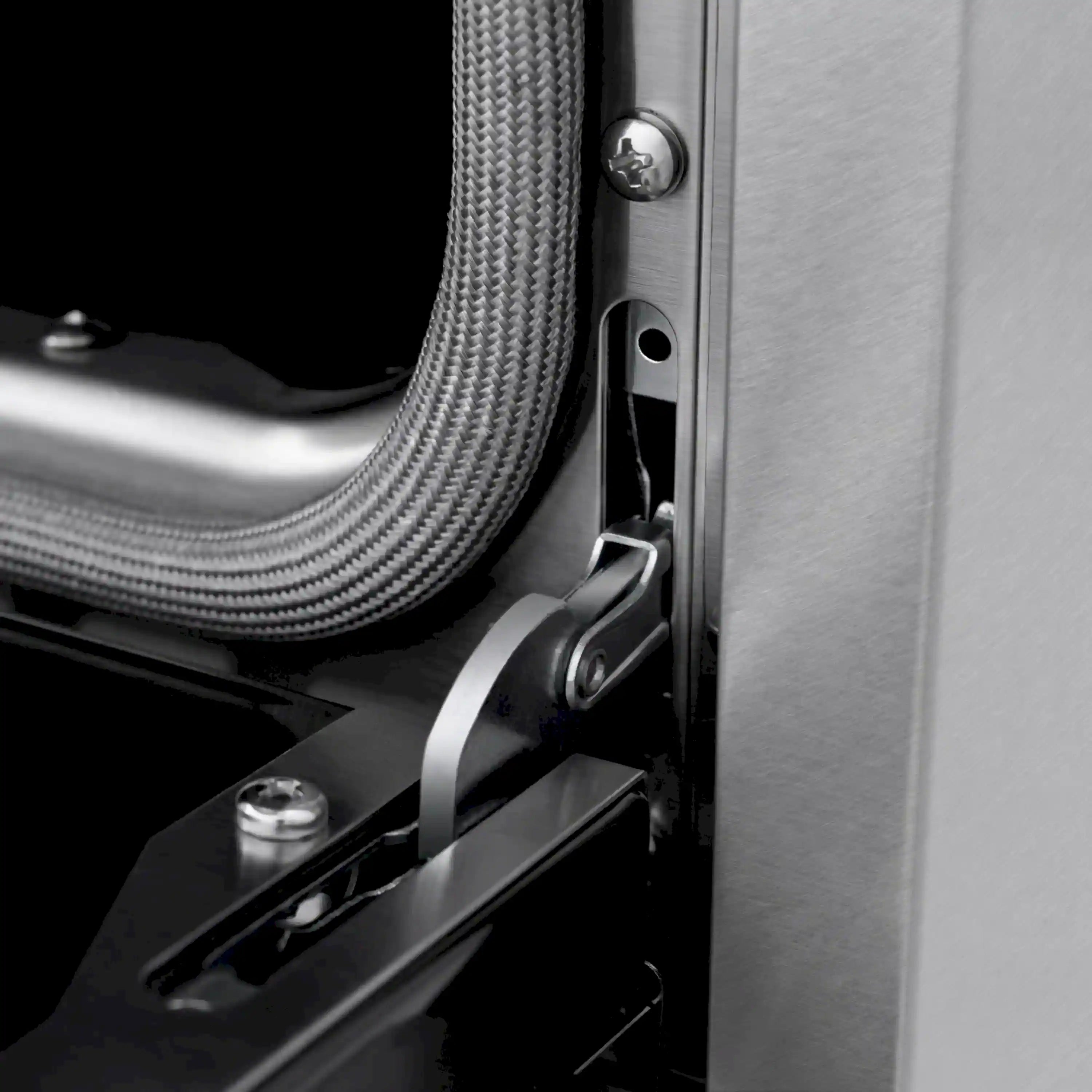 Close-up of range cooktop valve and metal side bracket with connected flexible gas line