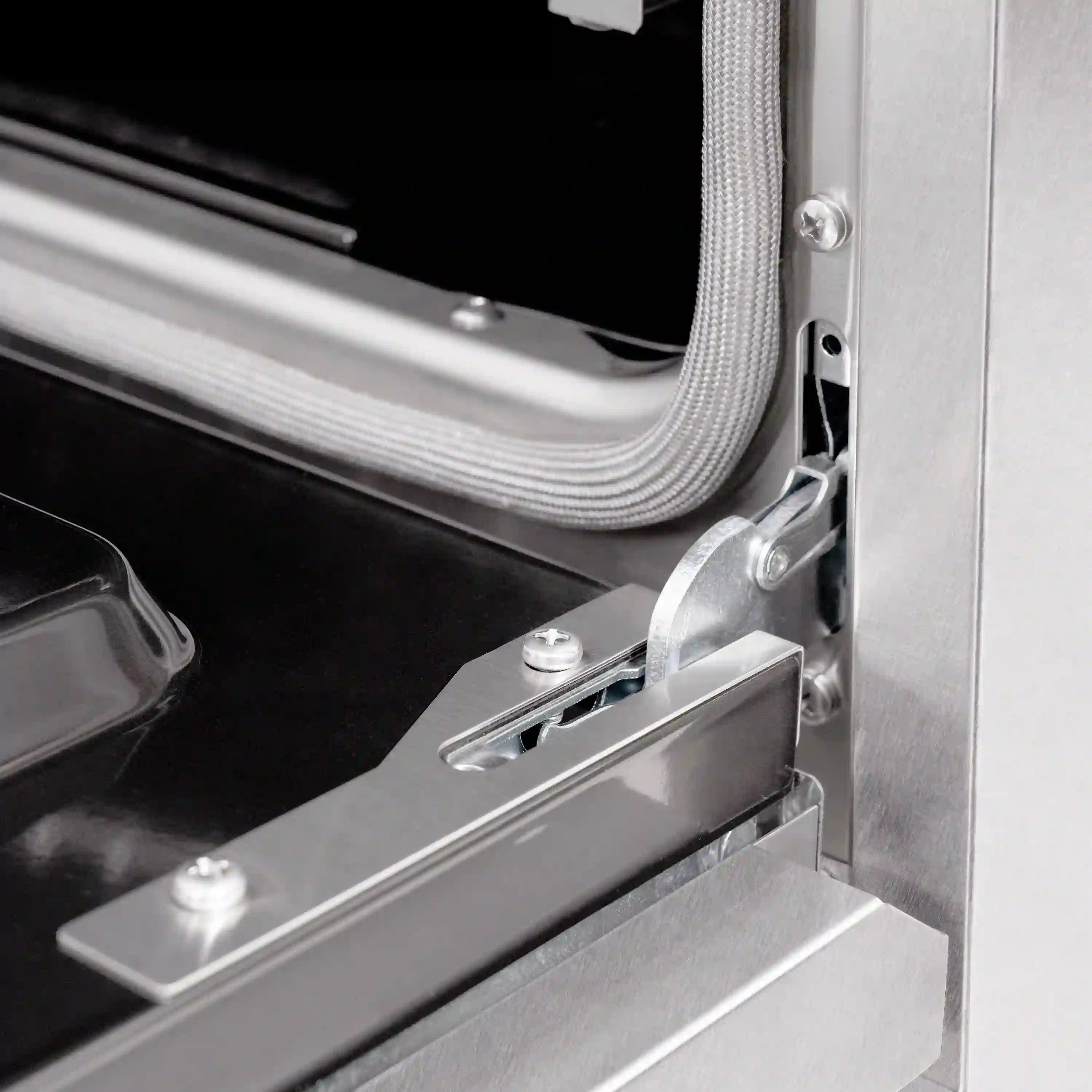 Gas oven door area with stainless frame, hinge hardware, and inner shelf rail