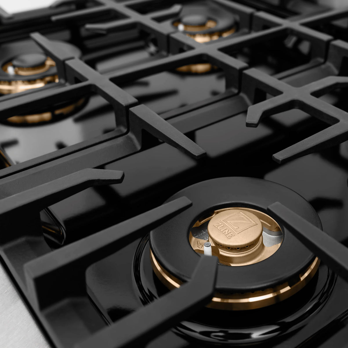 Gas cooktop burner cap centered on black grate with ZLINE medallion detail