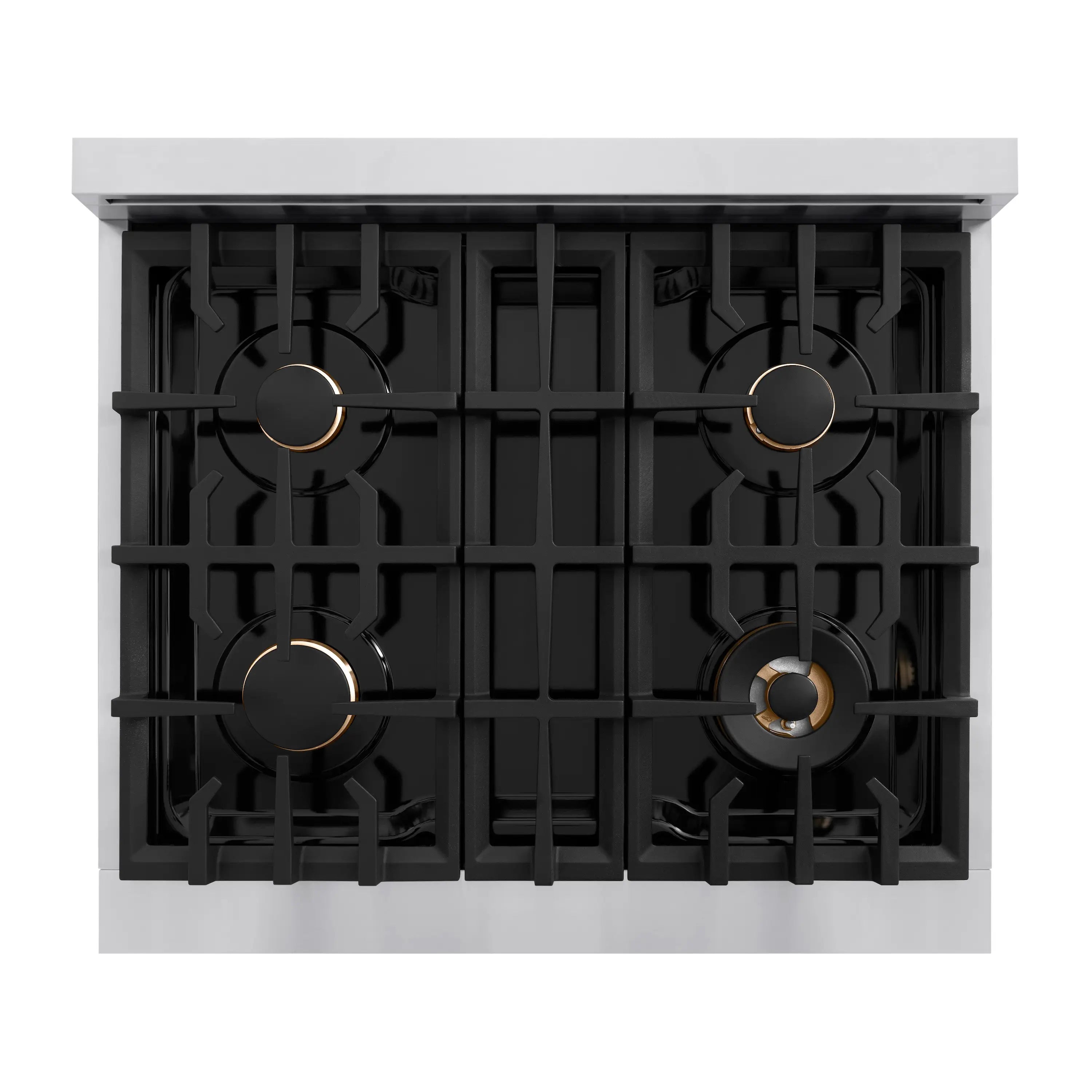 Four-burner cooktop with black grates and brass-toned burner caps on stainless steel