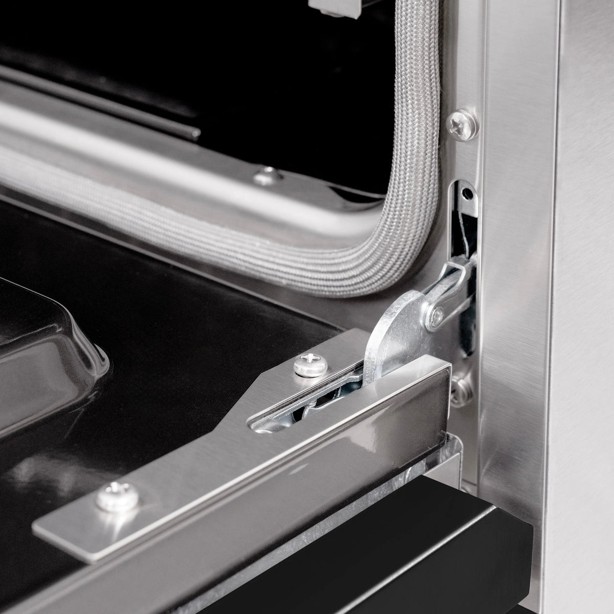 Stainless oven door hinge and latch hardware with black gasket edge detail
