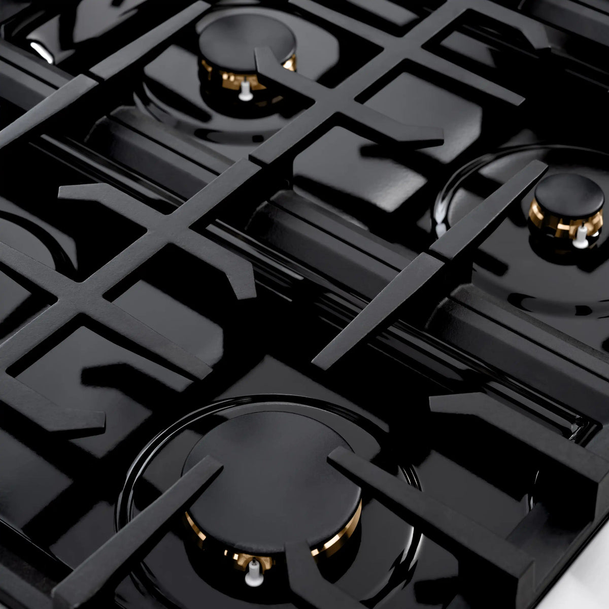 Gas cooktop top with brass burners and black grates on a stainless dual fuel range
