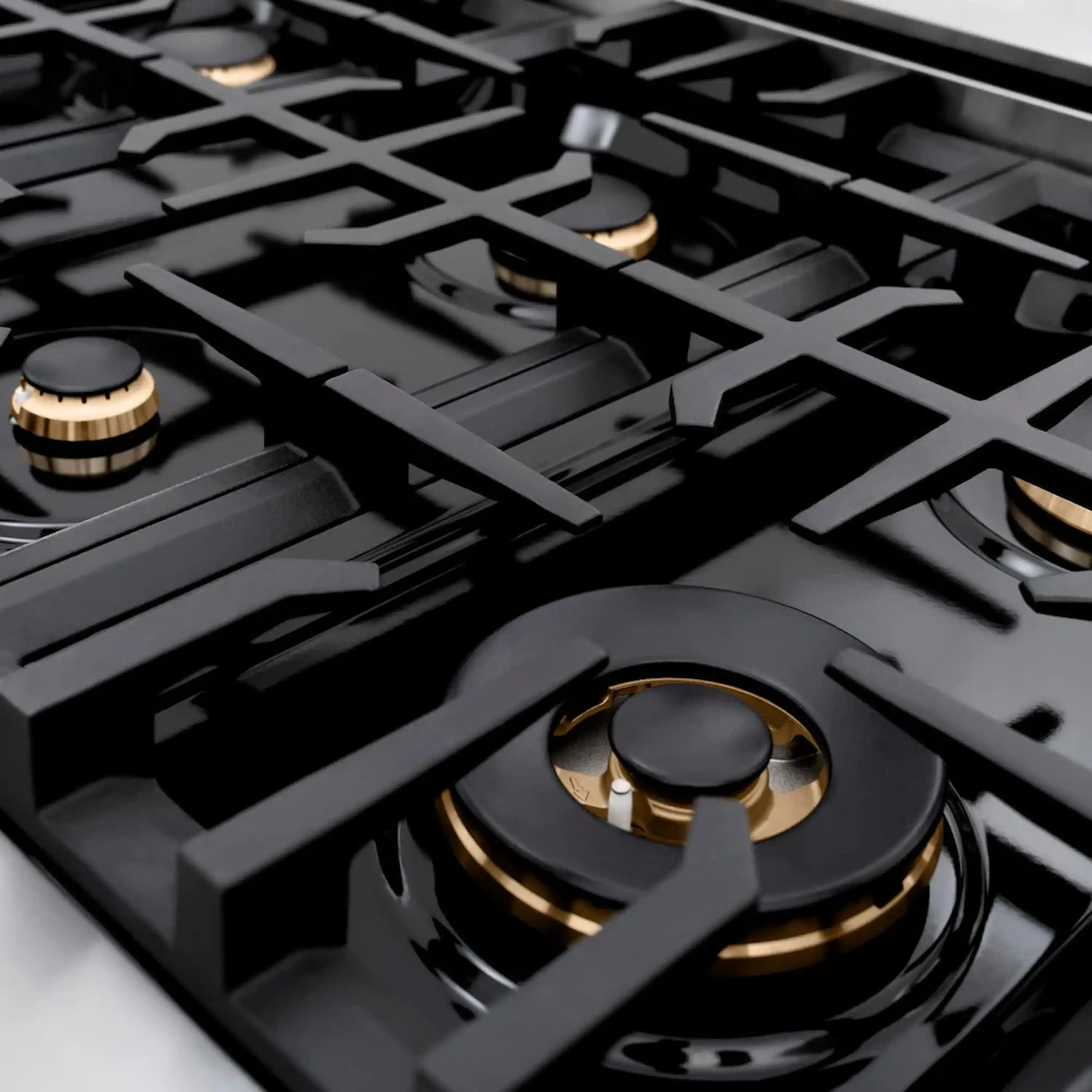 Black gas cooktop burner with gold-trim ring and dark grates