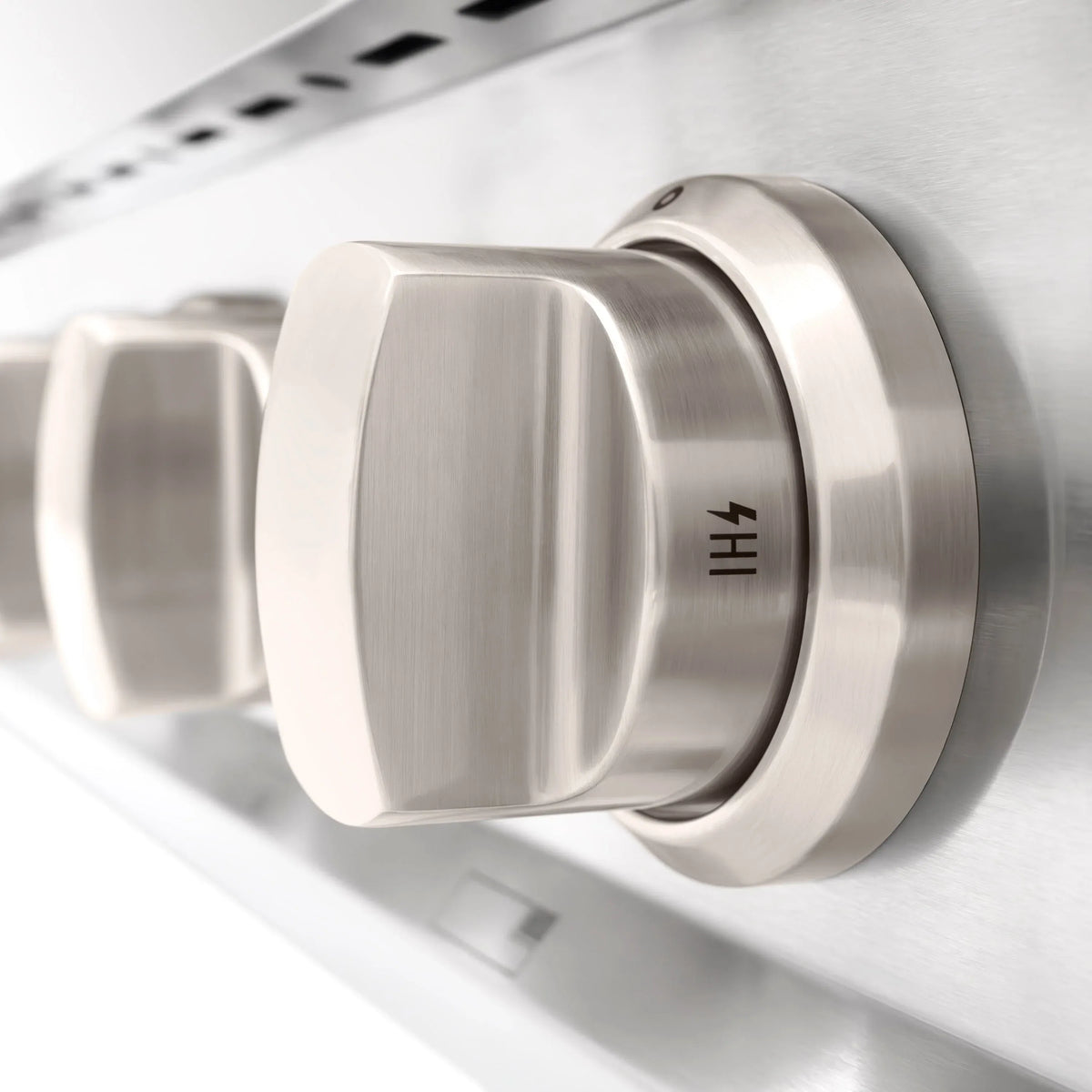 Stainless steel gas rangetop control knob on brushed metal burner base