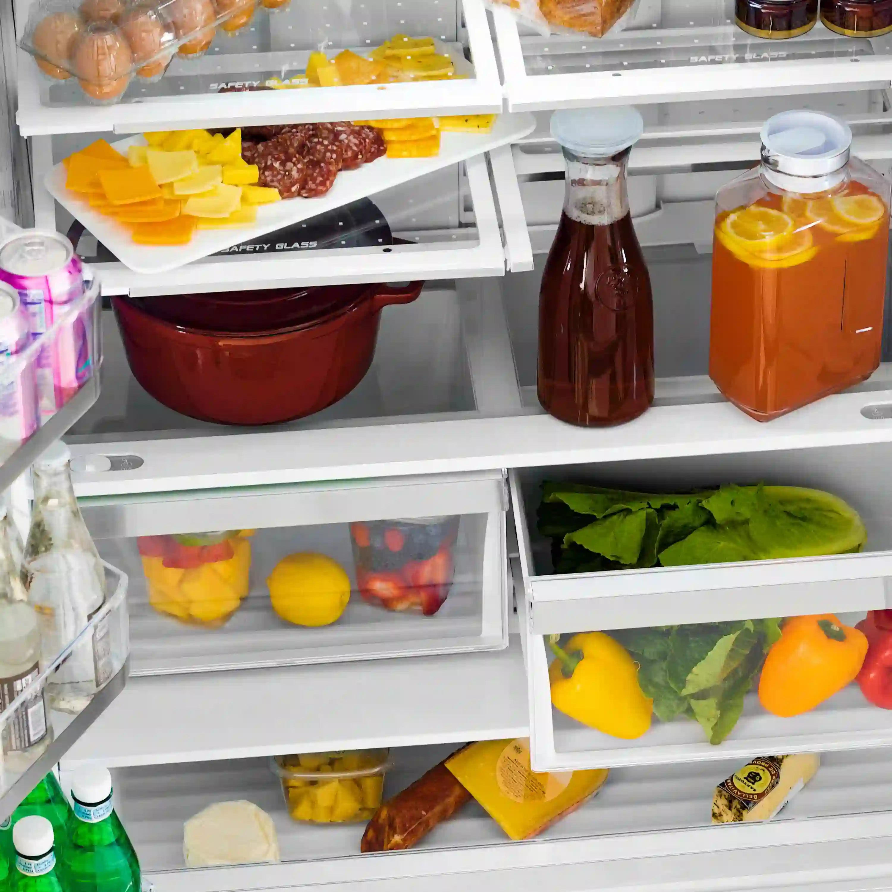 Refrigerator interior with produce drawers, bottles, and organized food containers