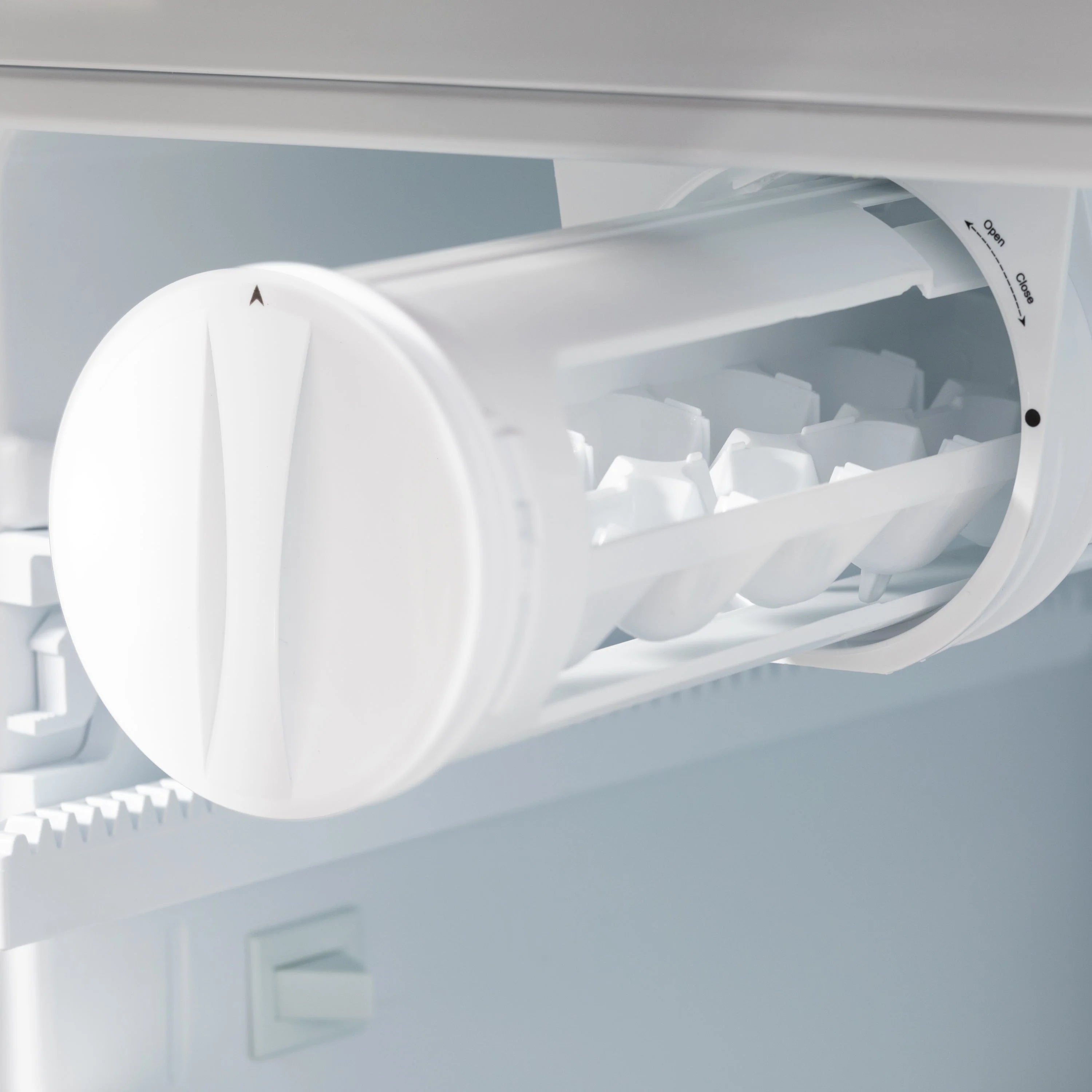 Counter-depth refrigerator ice maker bin and chute, white plastic, open side view