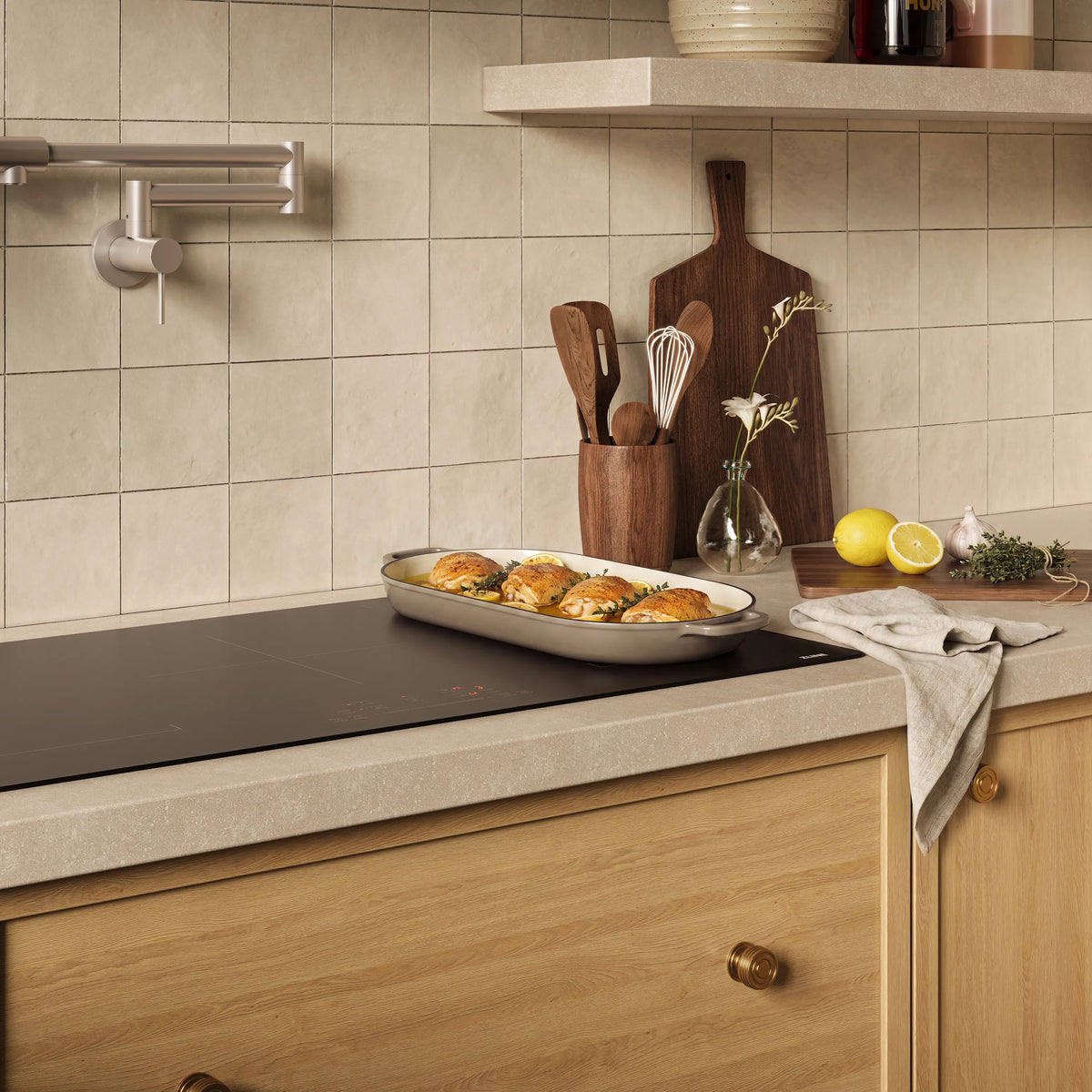 Induction cooktop on countertop with skillet and countertop utensil crock nearby