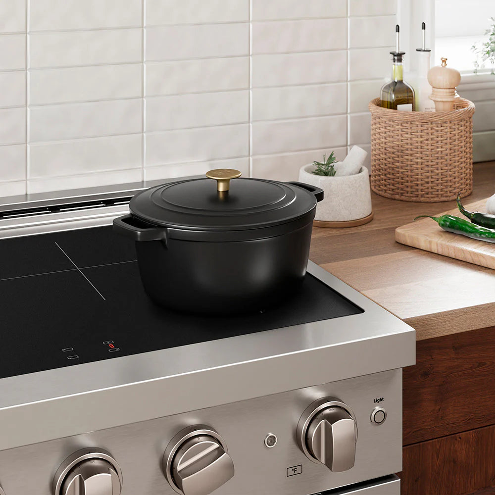 Matte black enameled cast iron Dutch oven on countertop electric cooktop