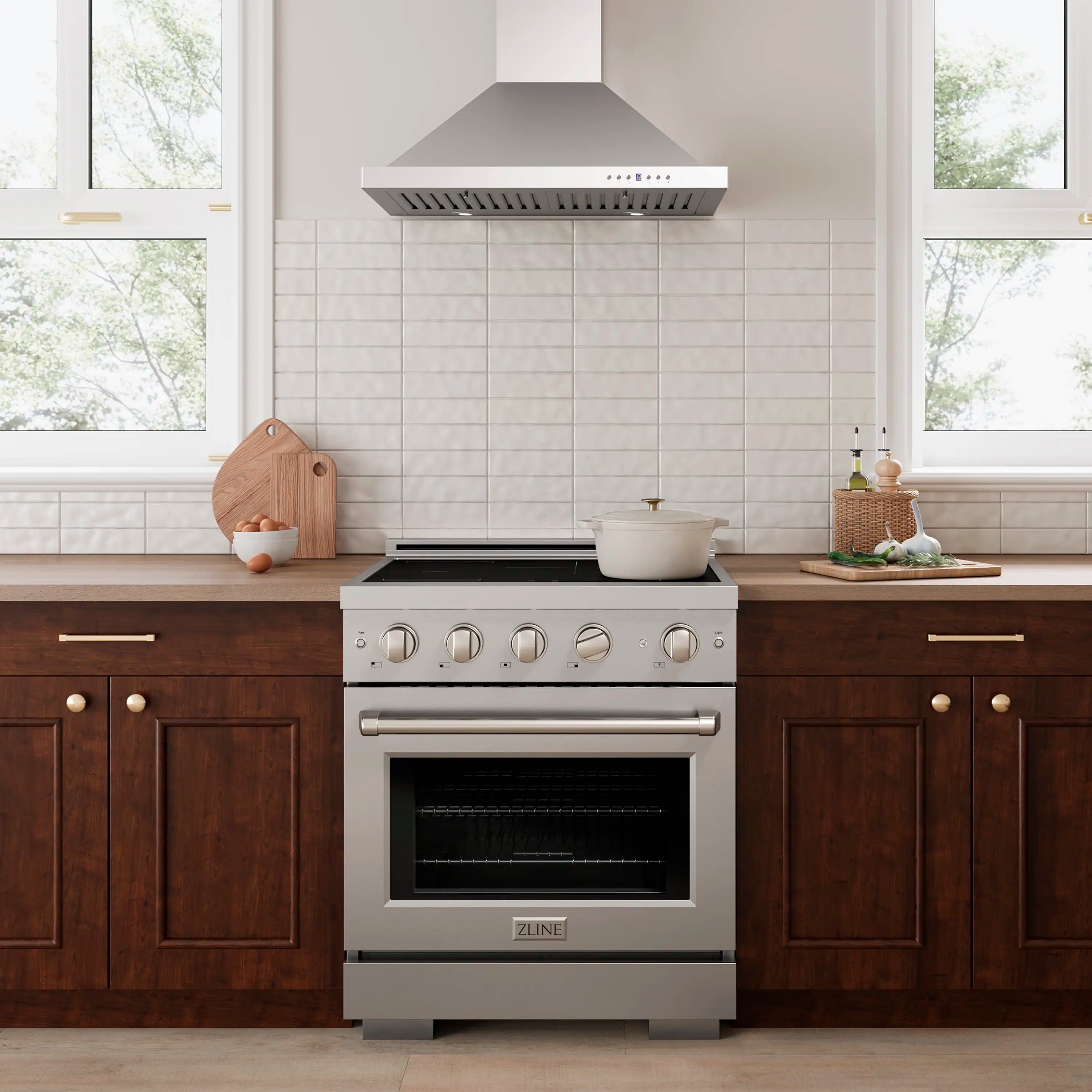 Stainless steel freestanding induction range with control knobs and oven door in kitchen