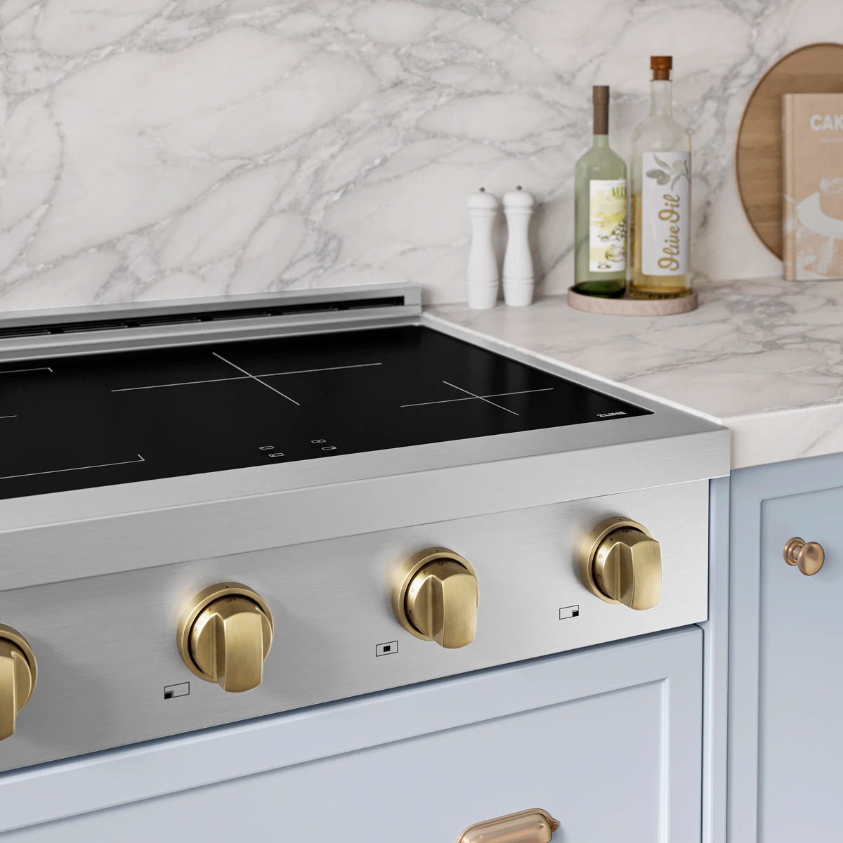 Induction cooktop with black glass surface and champagne-bronze control knobs