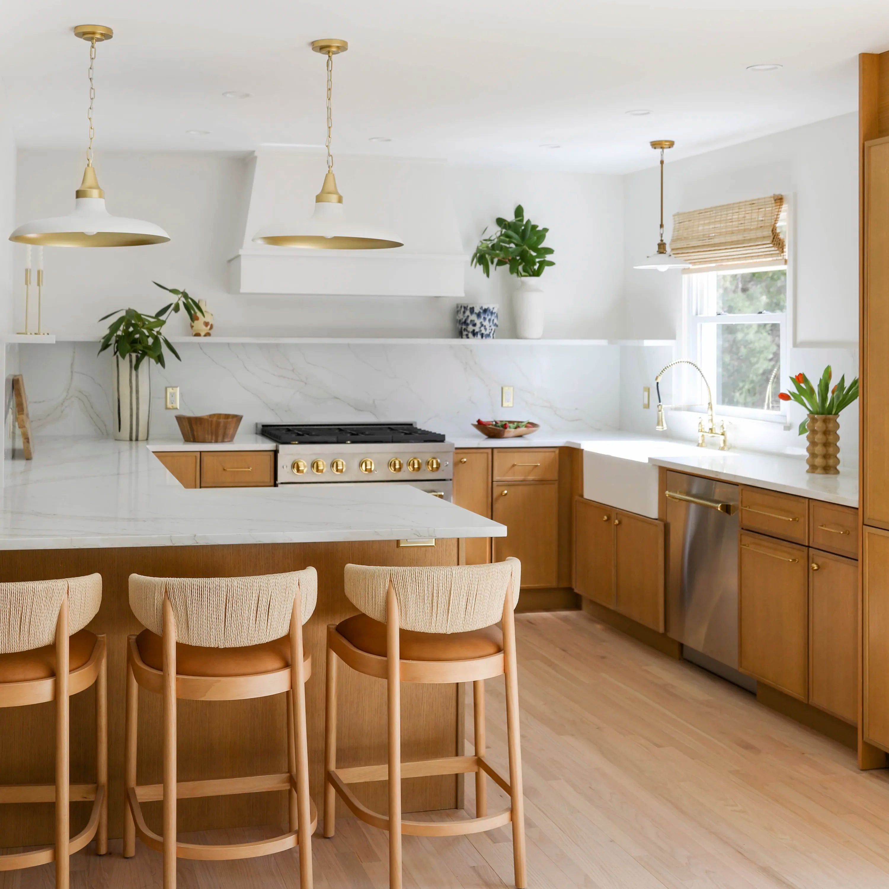 Built-in dishwasher with brushed metal door and gold handle in a kitchen