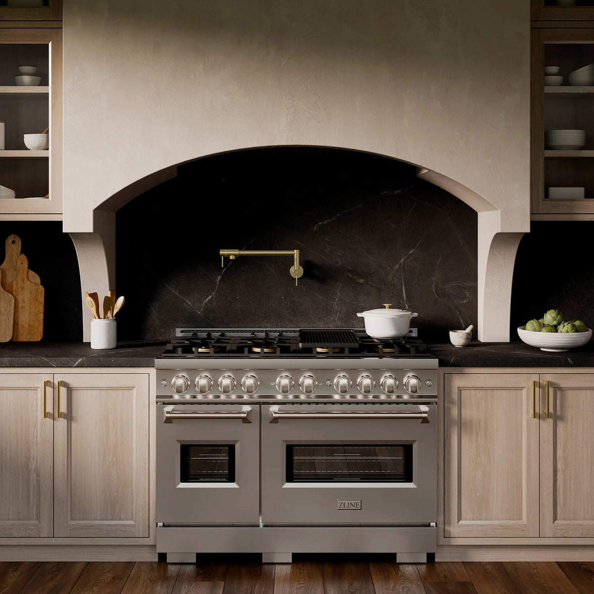 Stainless steel dual fuel range centered in cabinetry with lit burners across top