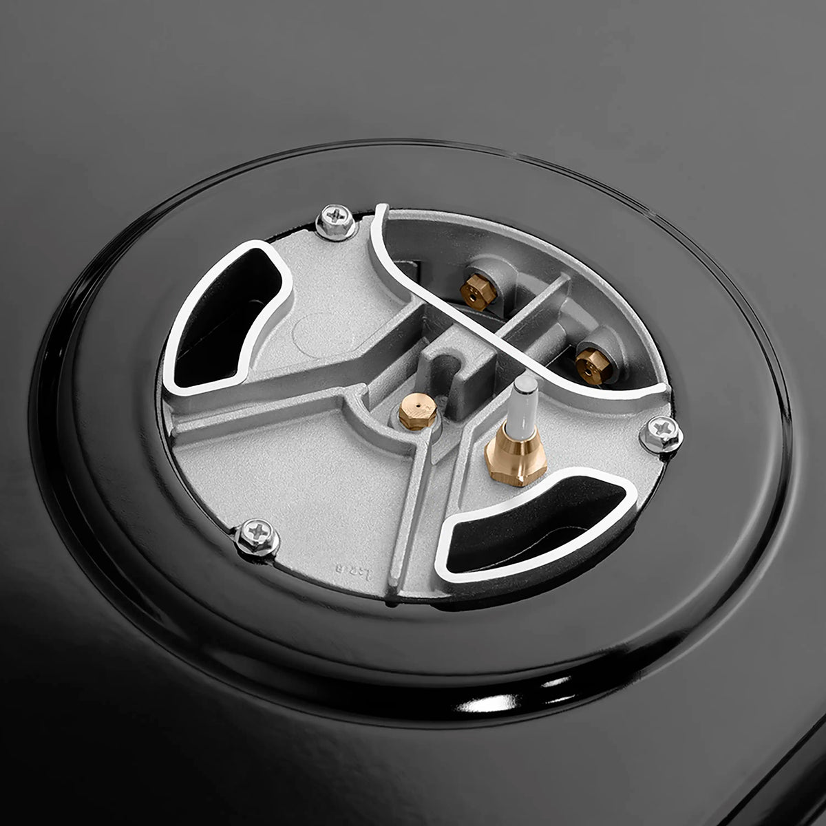 Close-up of a black burner valve base with metal components and bronze details