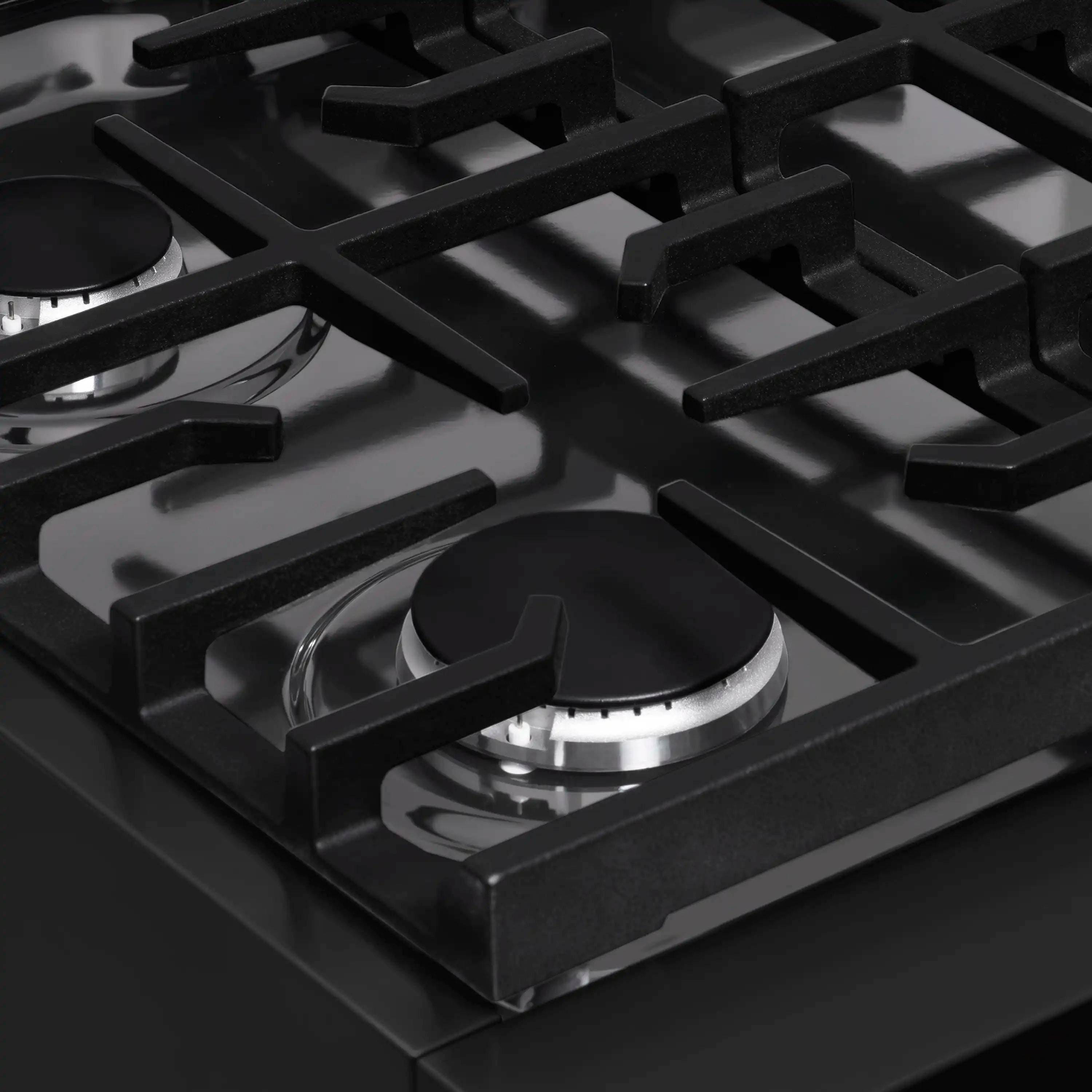 Close-up of black gas burners with cast-iron grates and spark burner heads