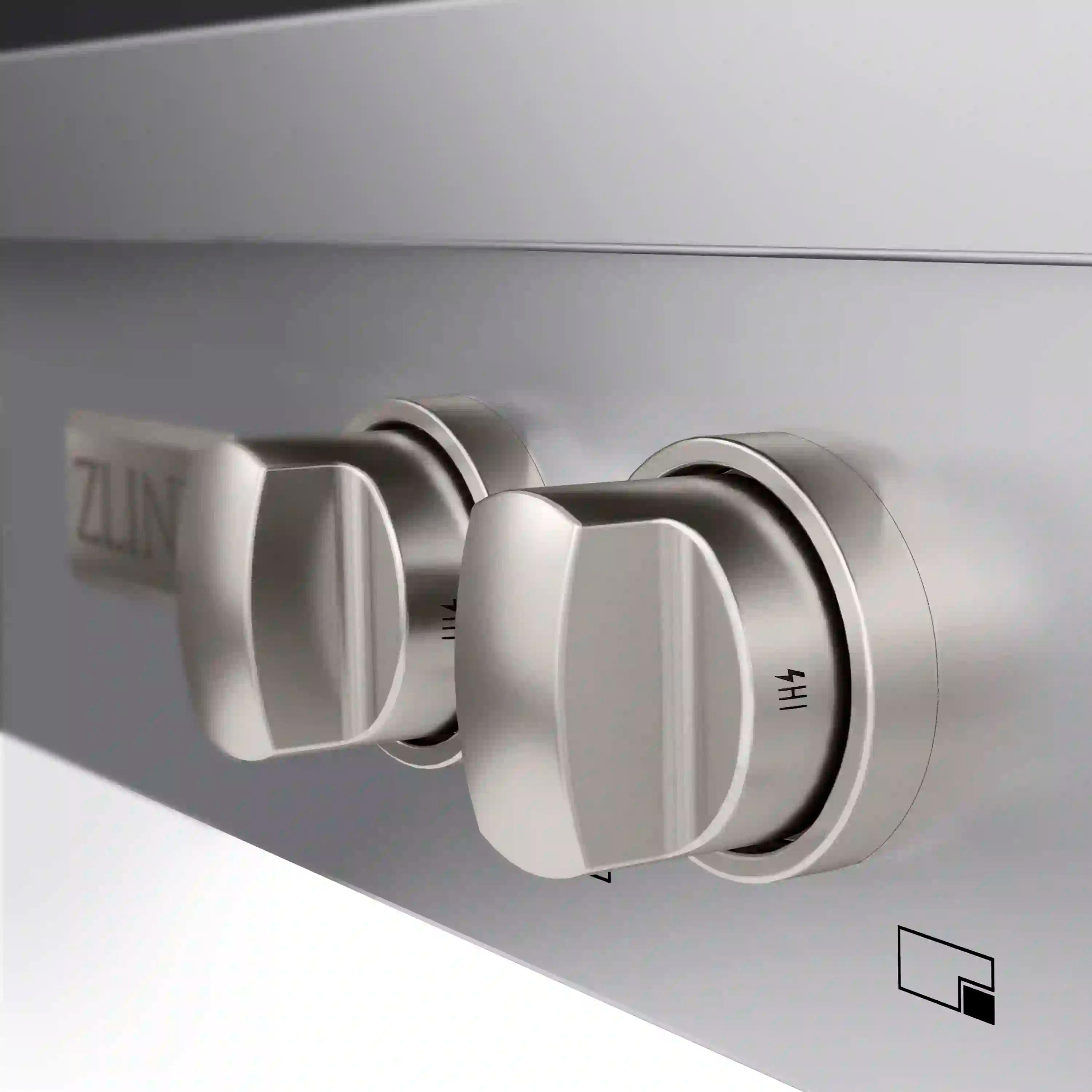 Stainless steel gas cooktop side controls with white knob caps and indicator mark