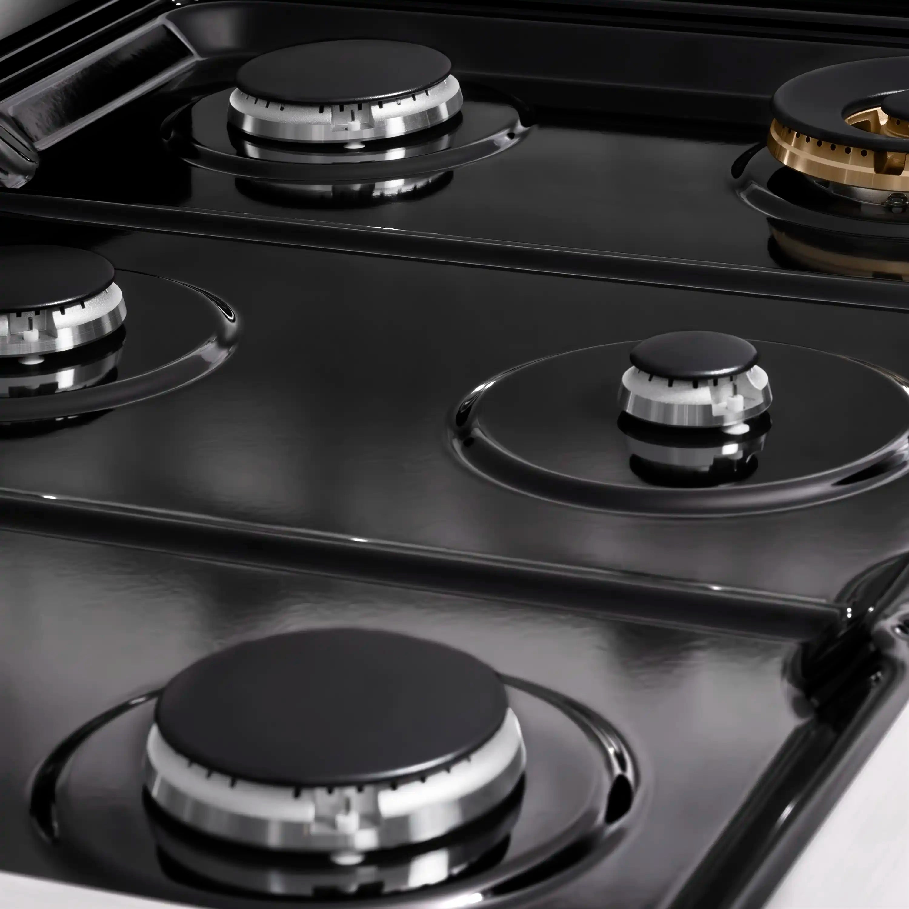 Black gas cooktop with four burner caps and glossy enamel surface