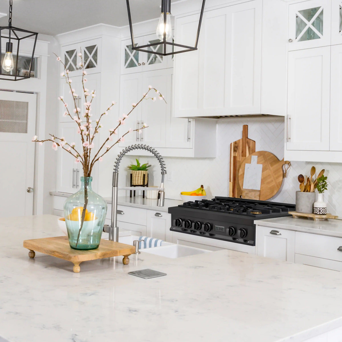 Black gas range with grates and burner knobs against a white kitchen backdrop
