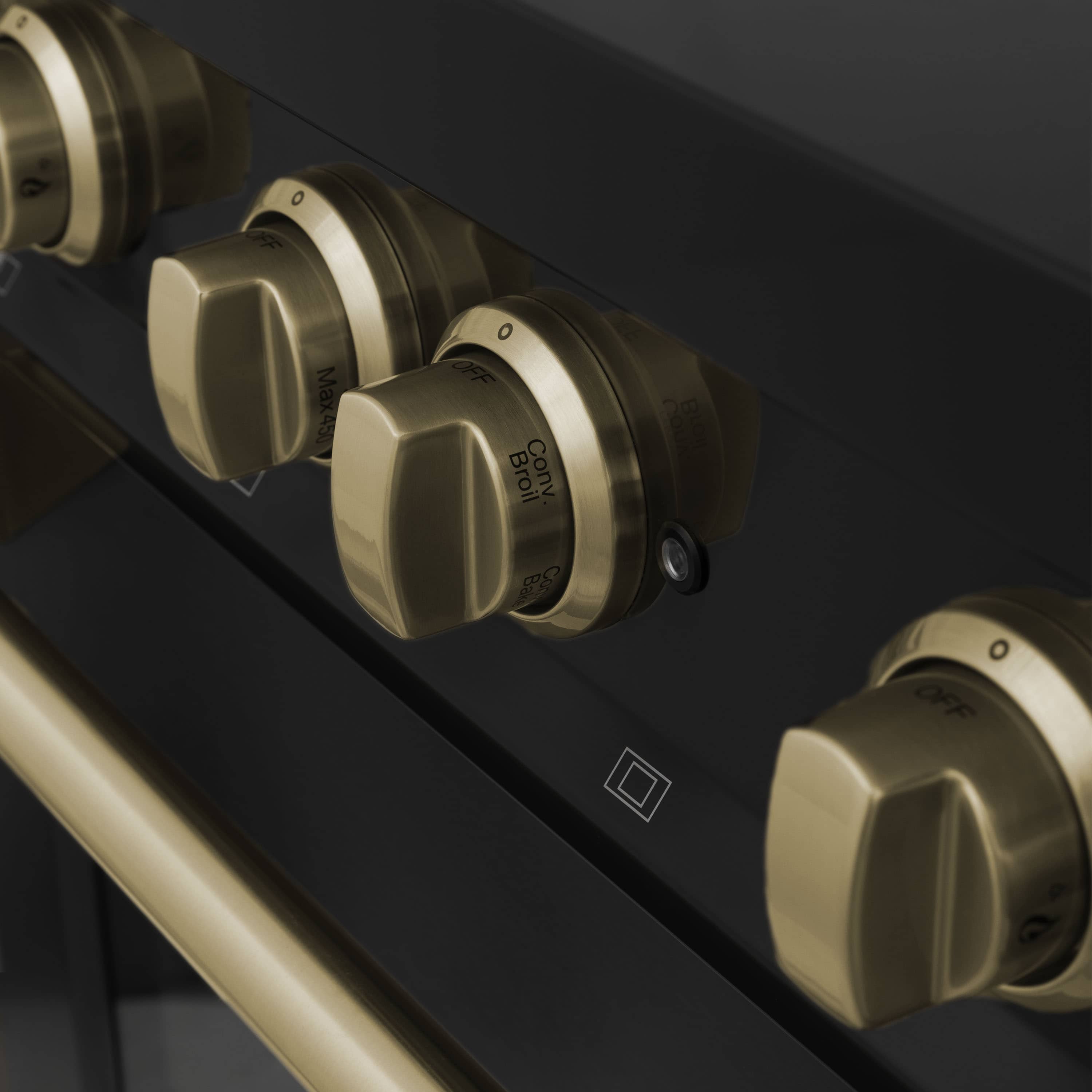 Black range front with champagne bronze burner knobs and control icons