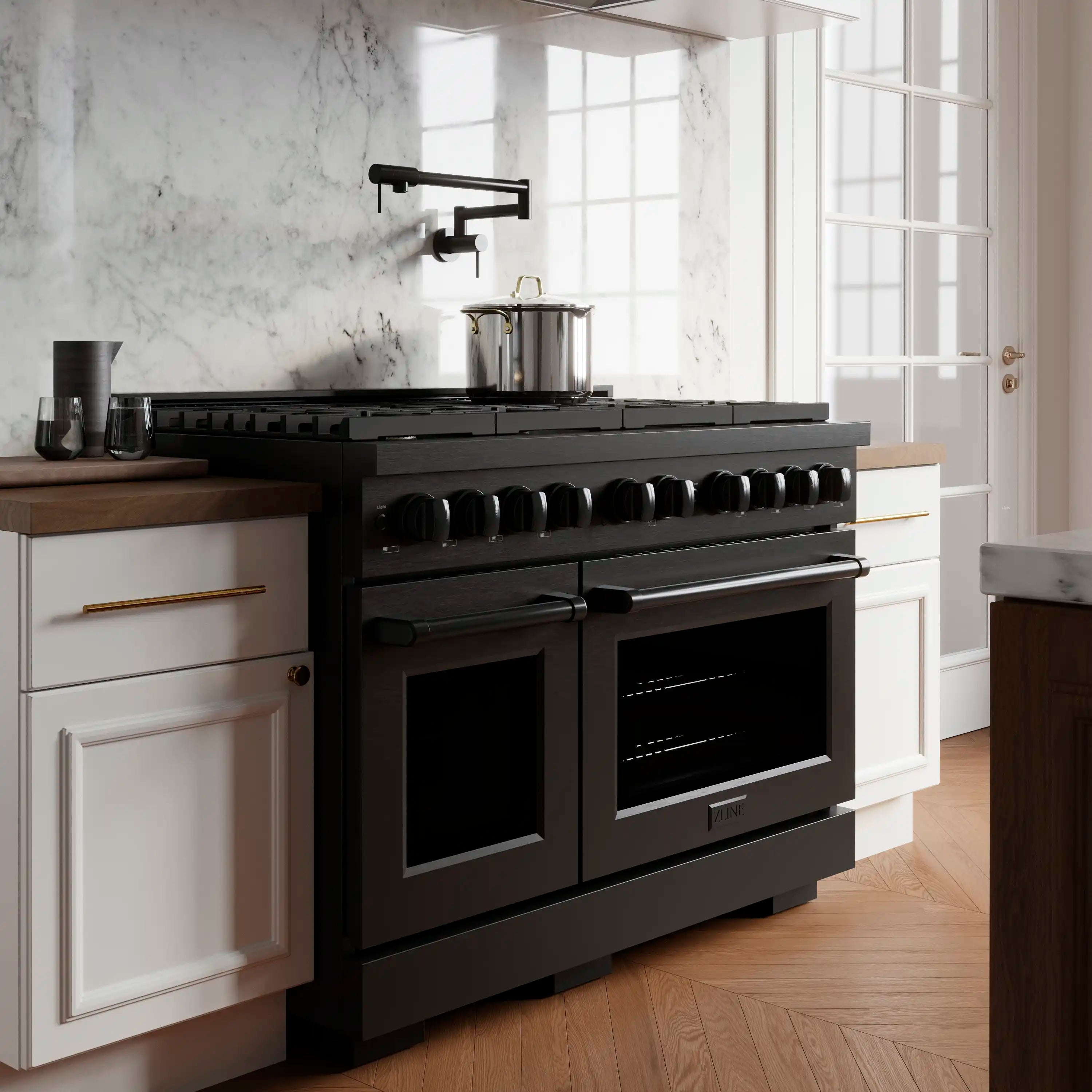 Black stainless steel range in kitchen with two ovens and cooktop burners