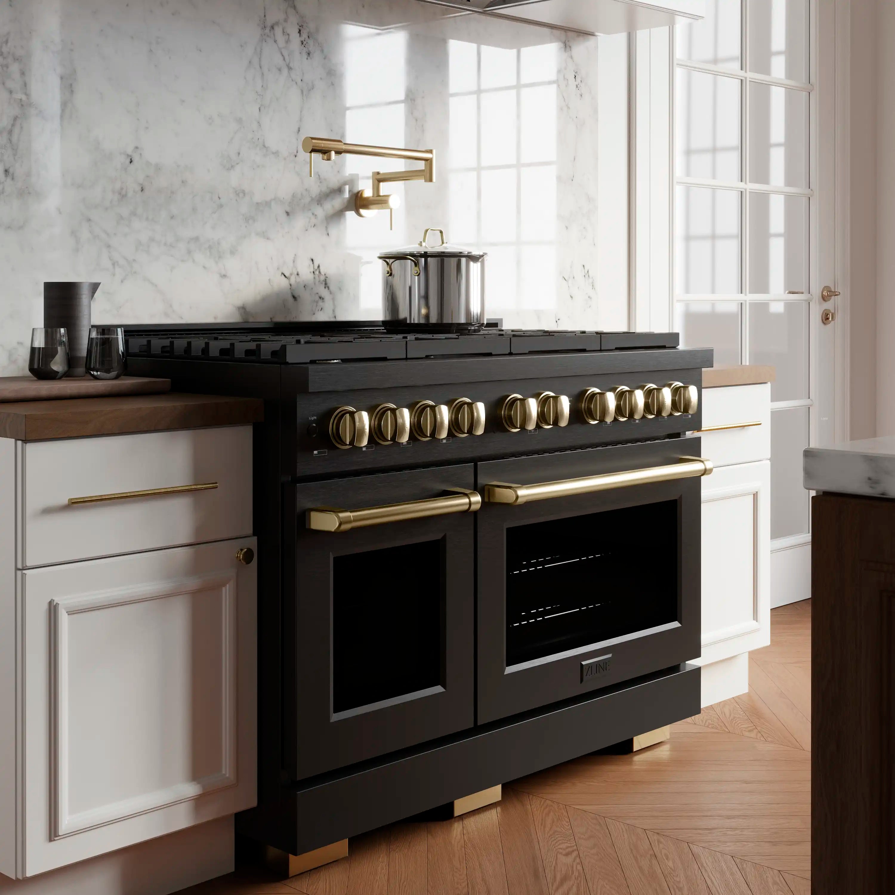 Black dual fuel range with gold control knobs, two oven doors, and burner grates