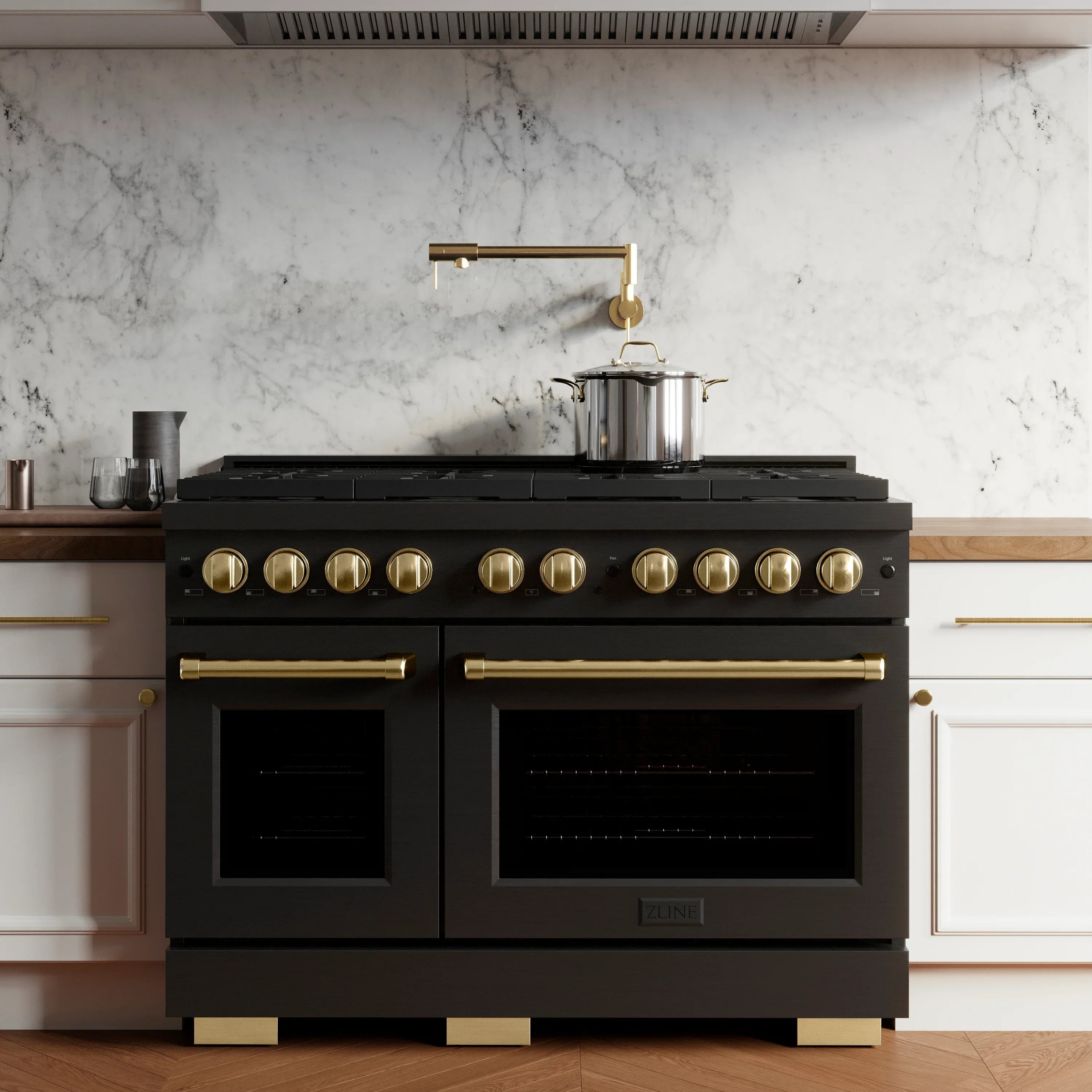 Black gas range with gold knobs and two oven doors in a kitchen setting