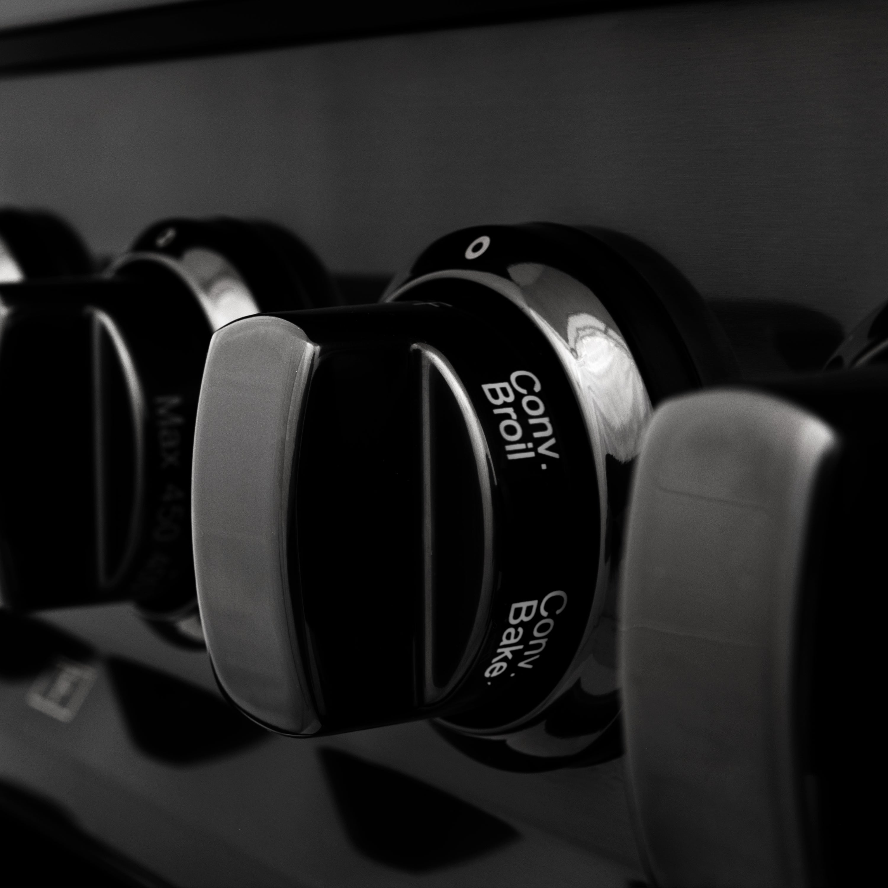 Black range control knobs with printed settings and icons