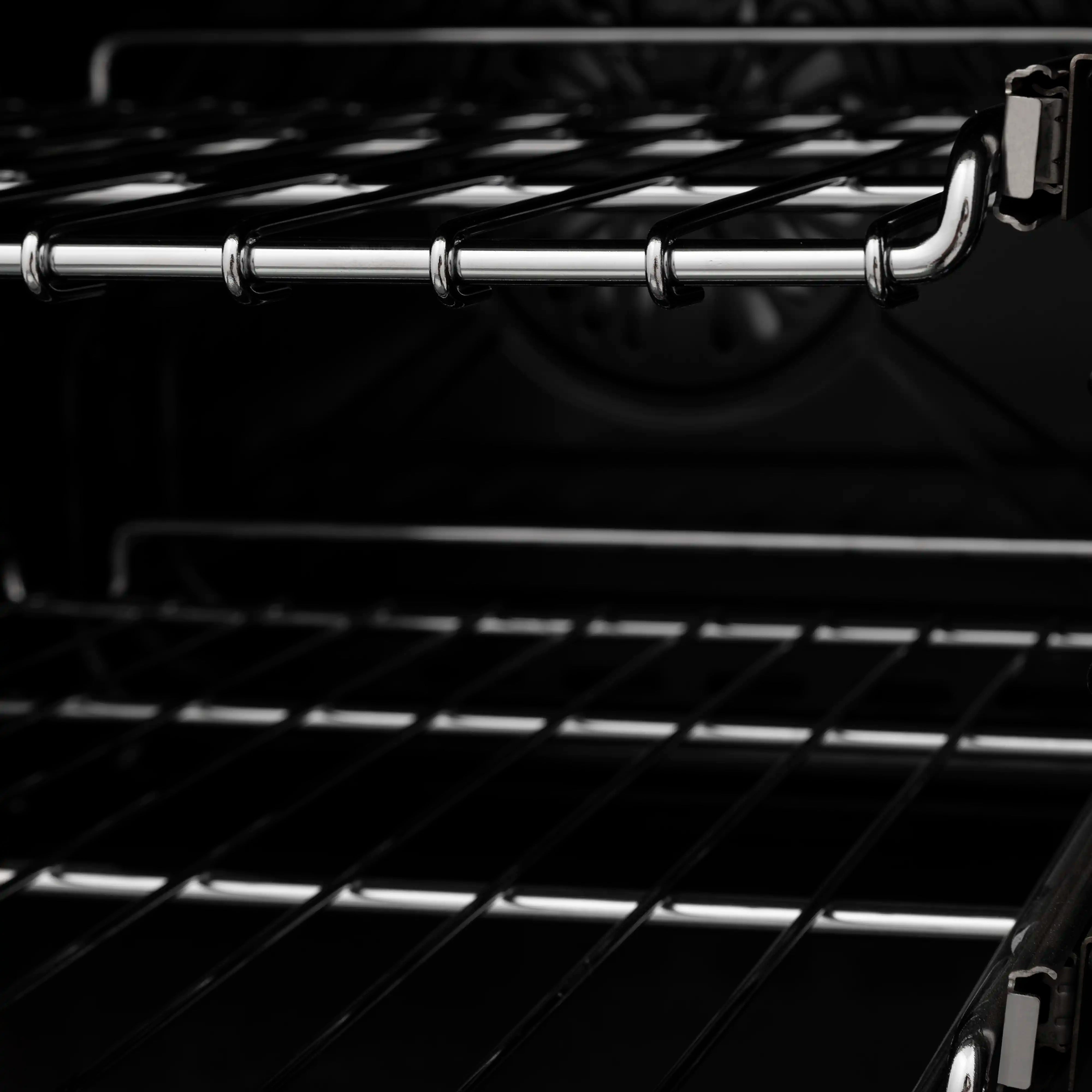 Dark oven interior with chrome rack rails and stovetop grates at the back