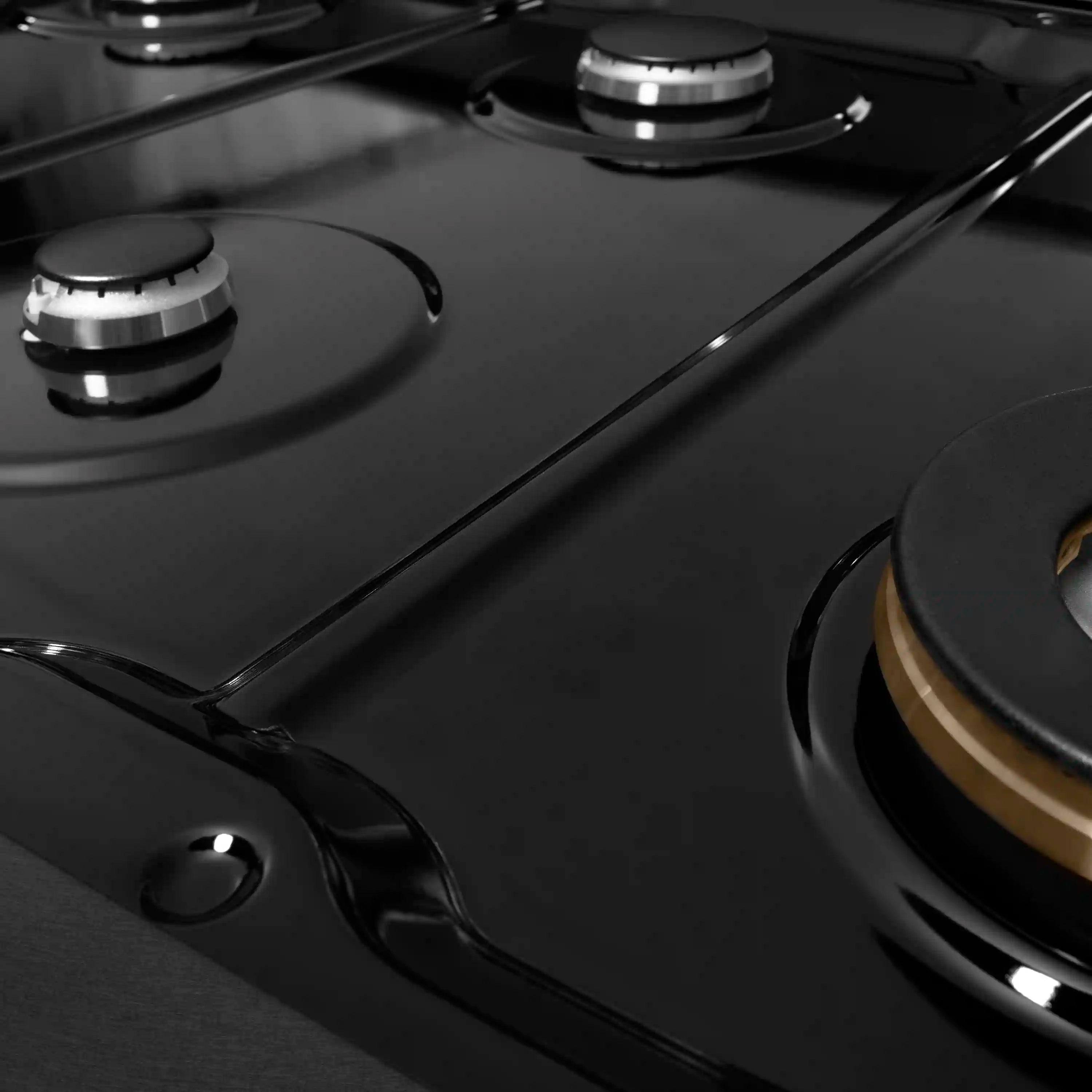 Black gas rangetop surface with multiple burner caps and cast grate supports