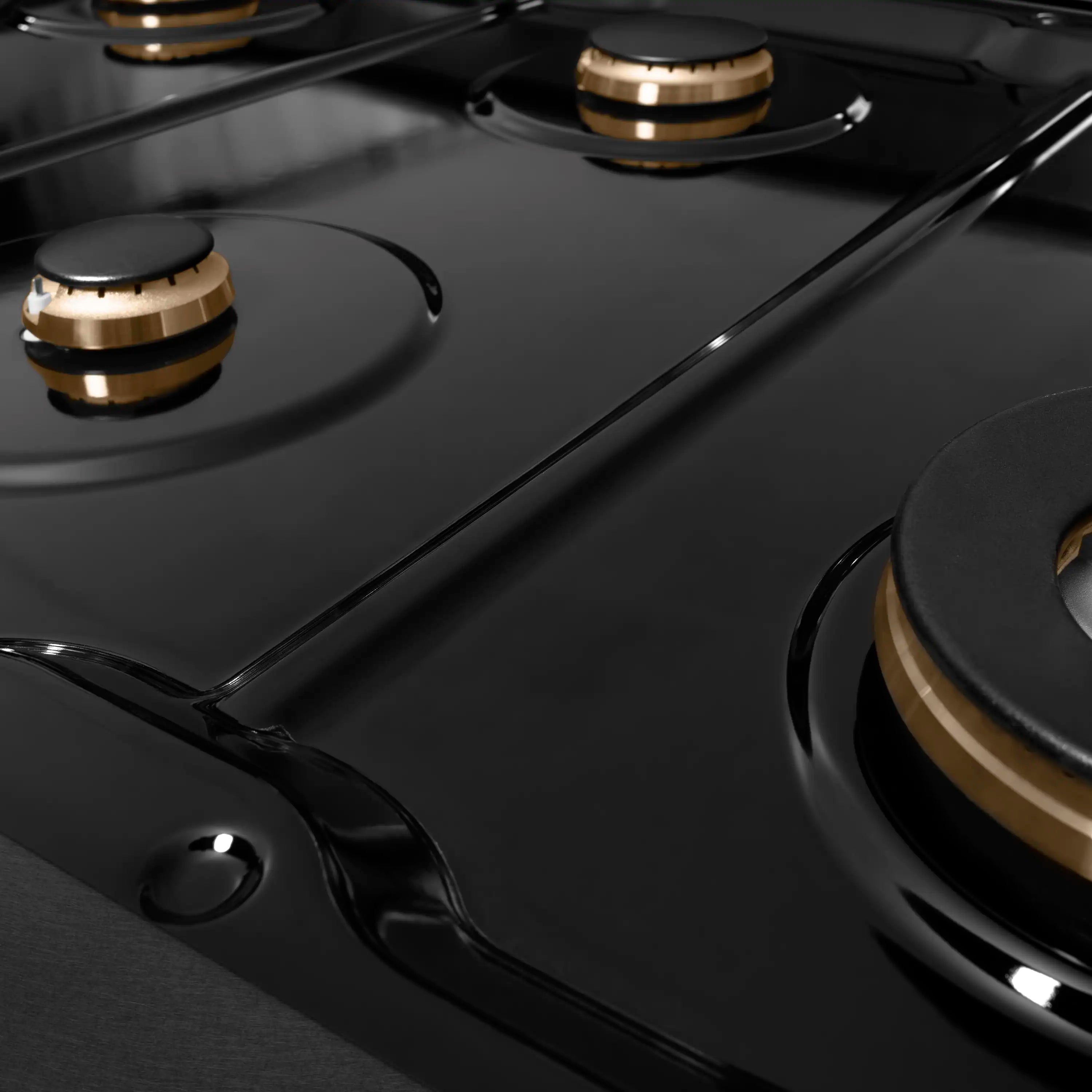 Black gas cooktop with burner caps and champagne-accented burner bases