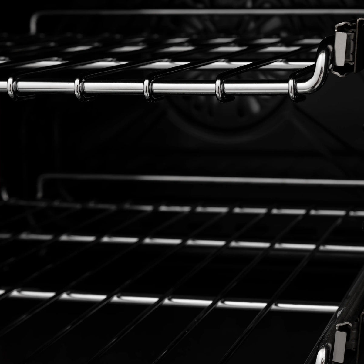 Close-up of electric oven interior with wire racks and black back panel