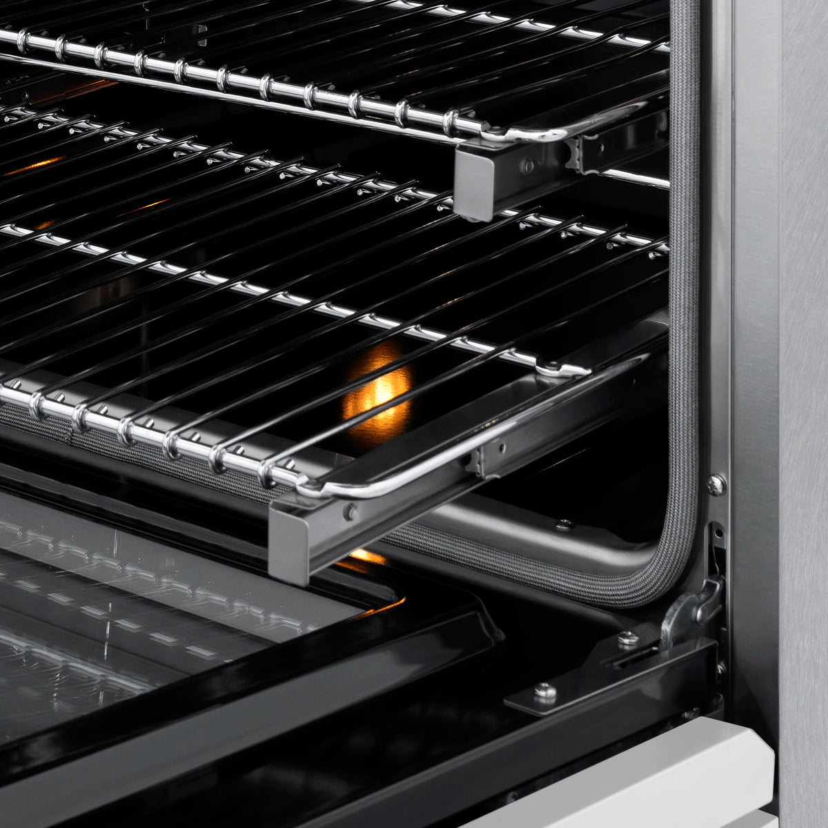 Dual fuel range oven interior with chrome racks and glowing heating elements