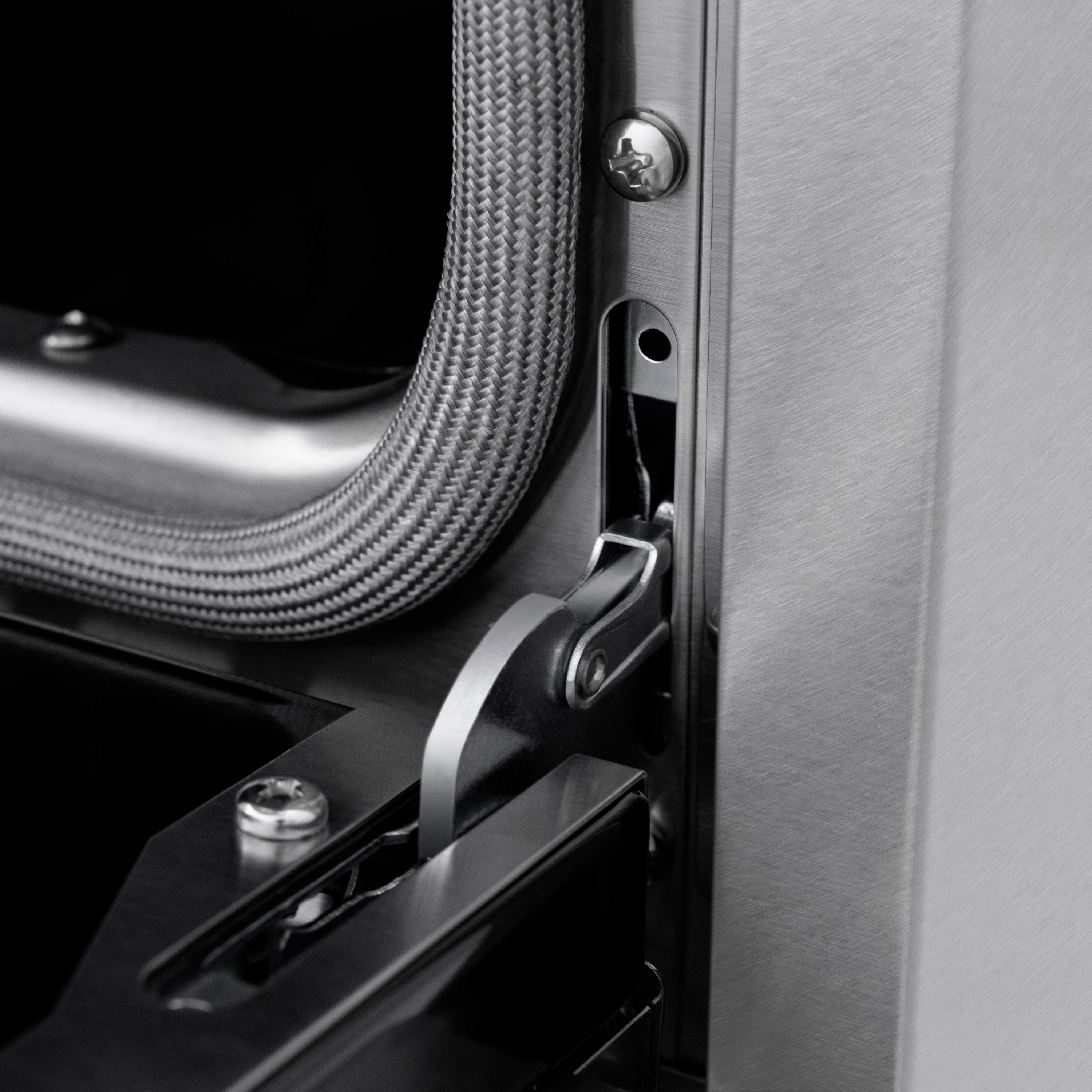 Matte black oven door handle and flexible gas connector on stainless side