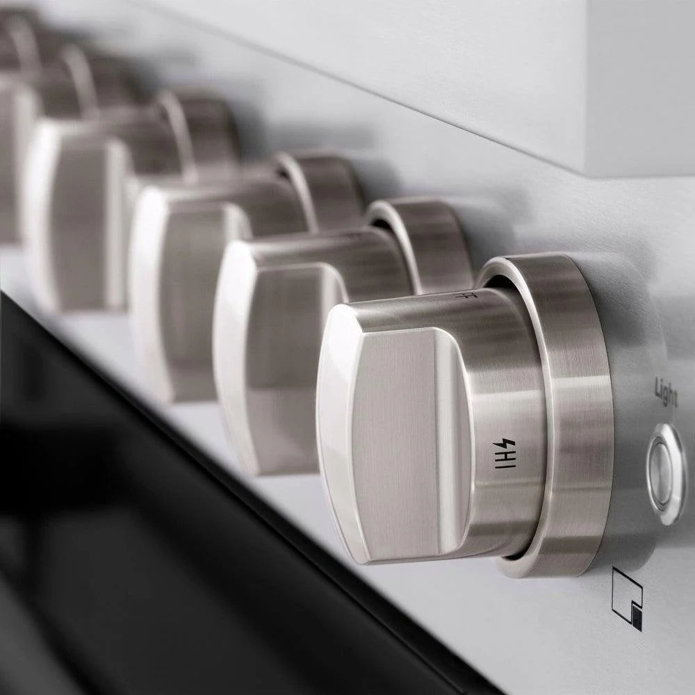 Close-up of burner knobs and cooktop control area on stainless panel