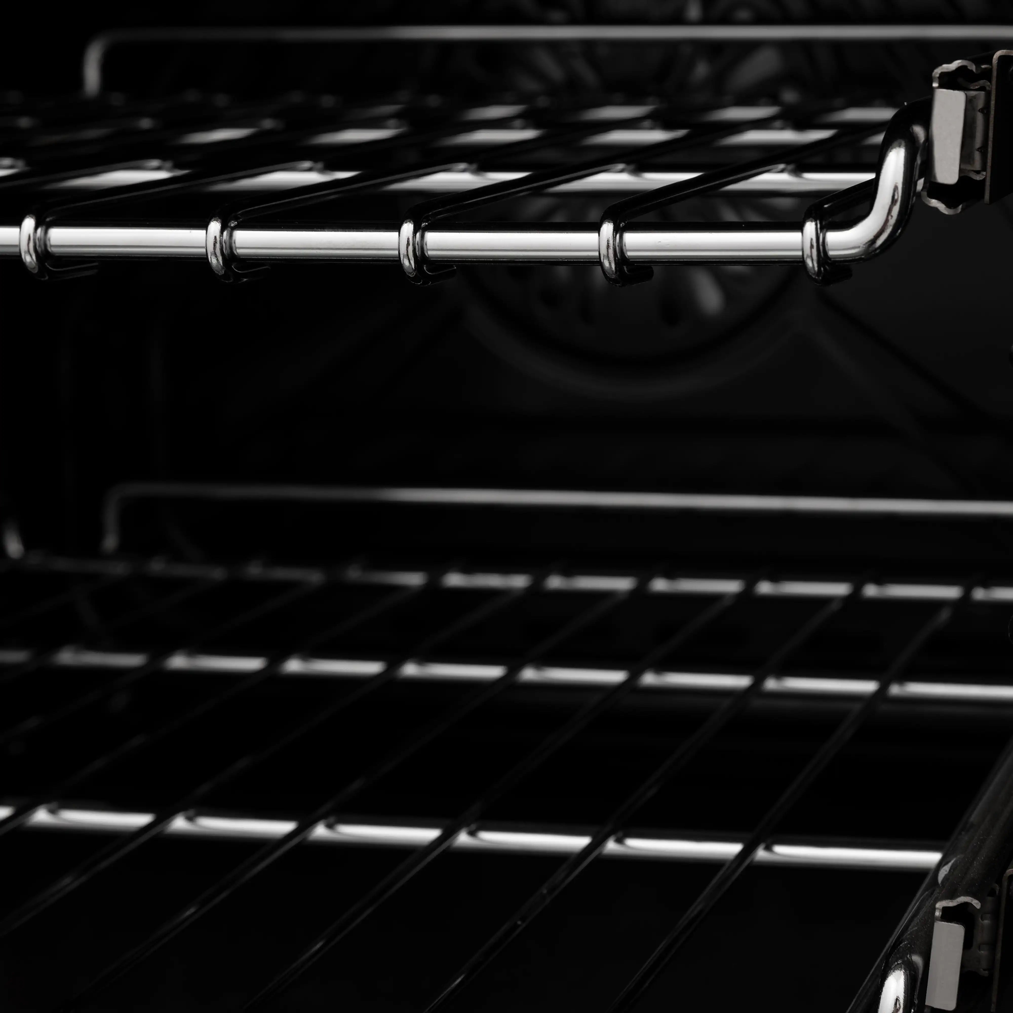 Black oven interior with chrome rack guides and metal support brackets