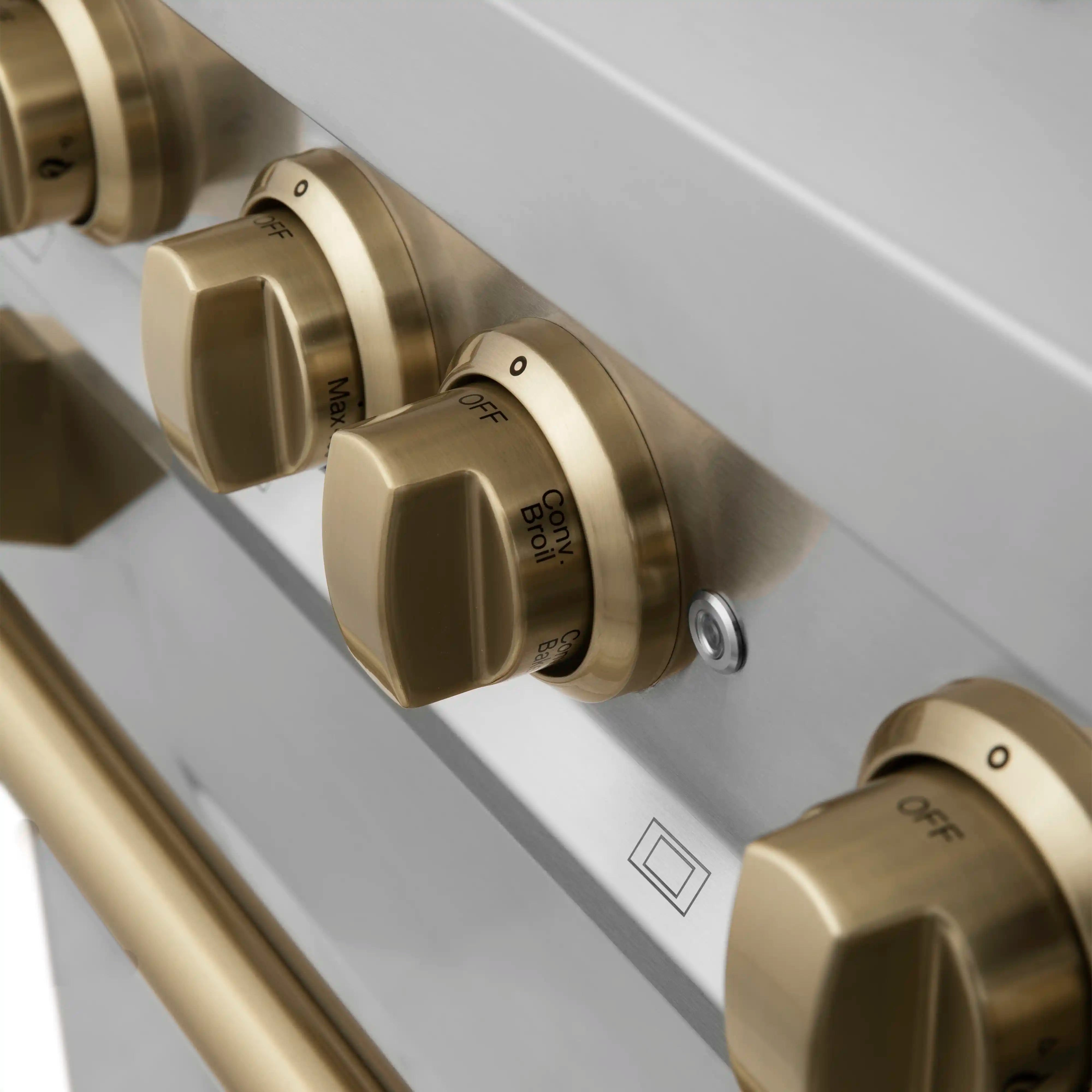 Champagne bronze control knobs on stainless range with small indicator markings