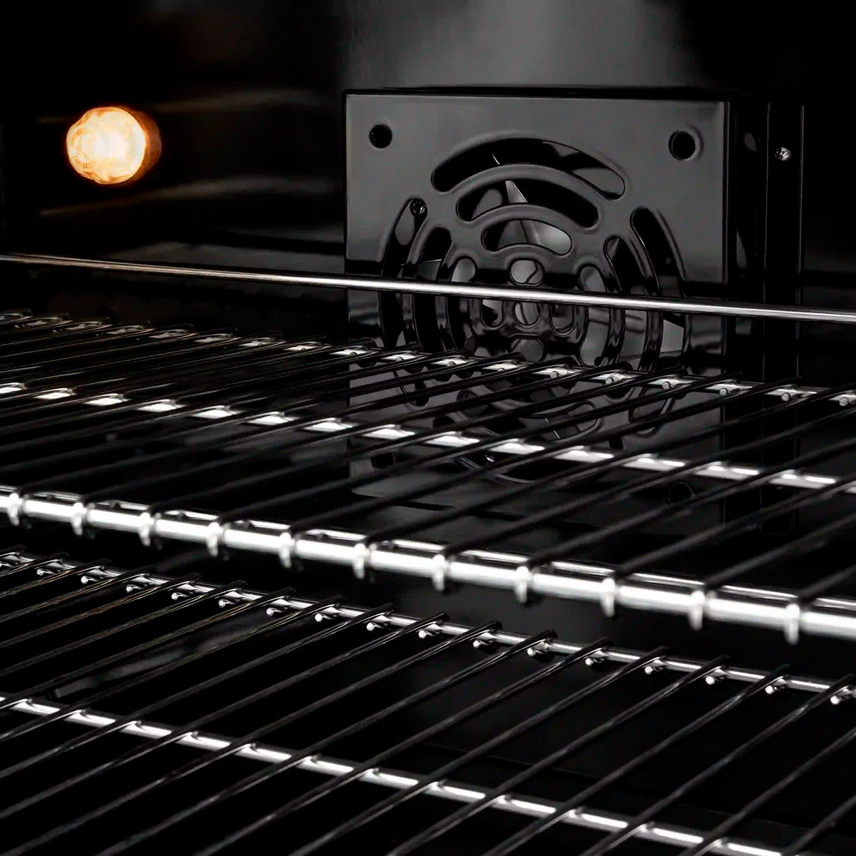 Black grates over an illuminated dual fuel burner with stainless cooktop surface