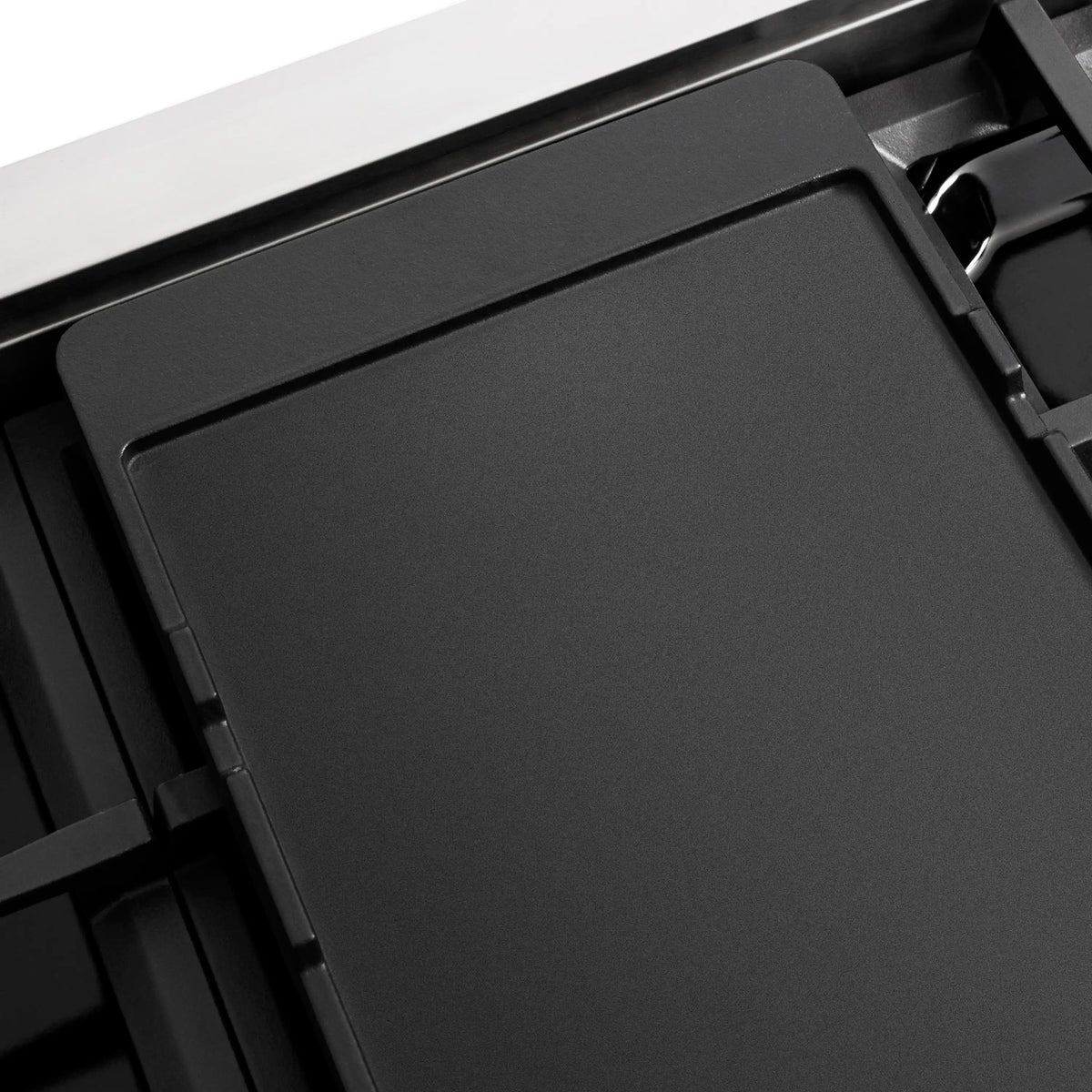 Dual fuel range cooktop with smooth black cover panel and surrounding metal grates