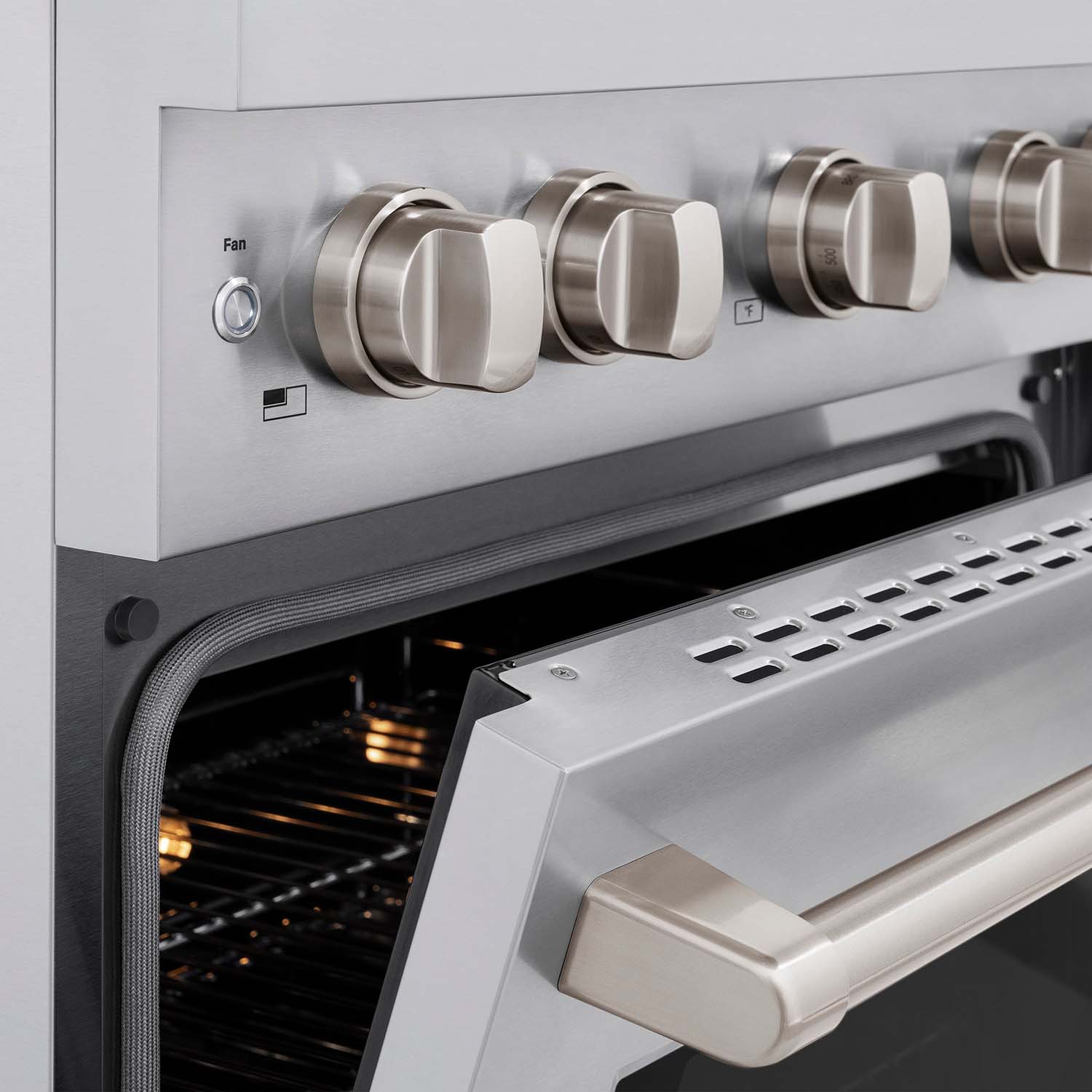 Stainless steel gas range control panel with knobs and oven door handle