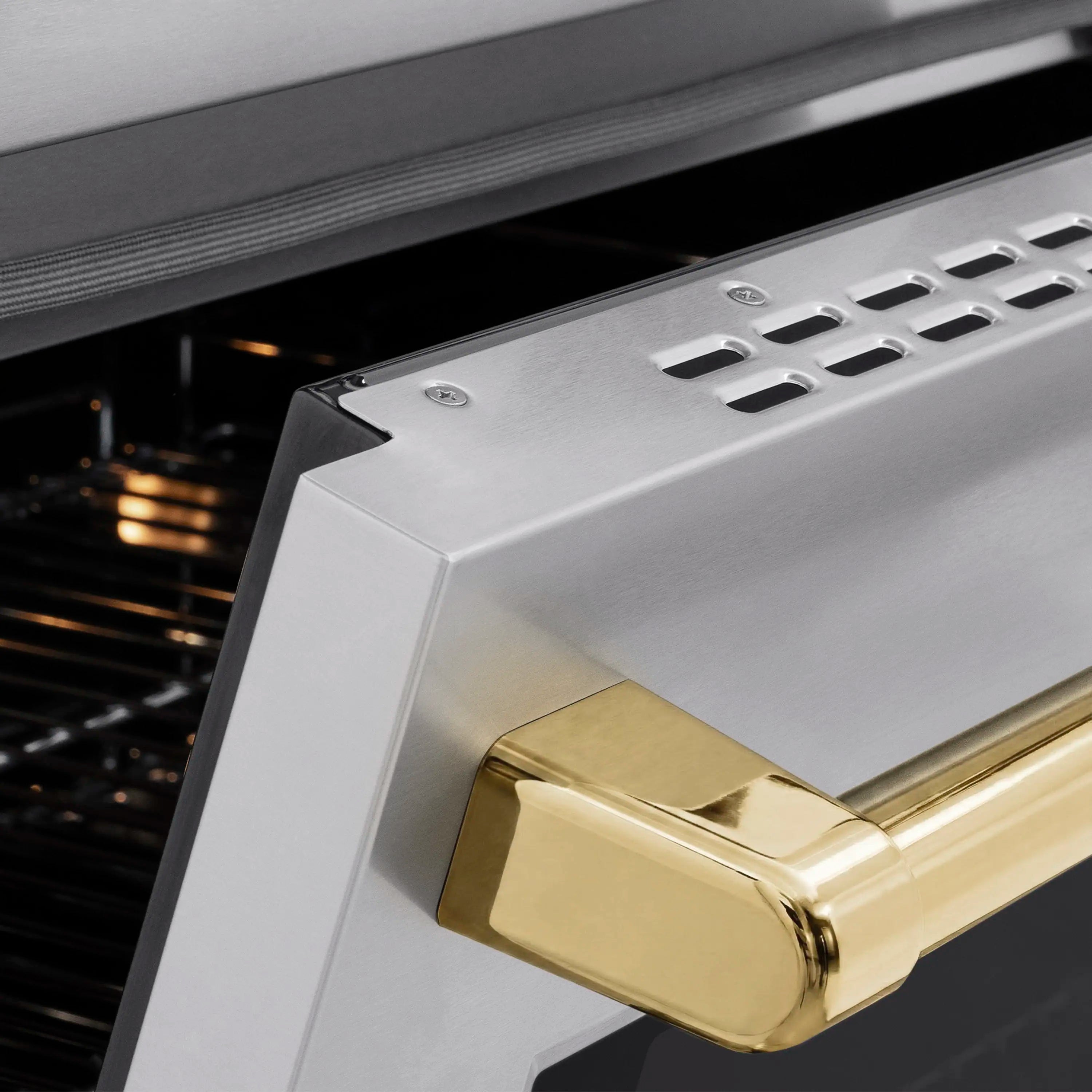 Stainless oven door with polished gold handle and vented side trim