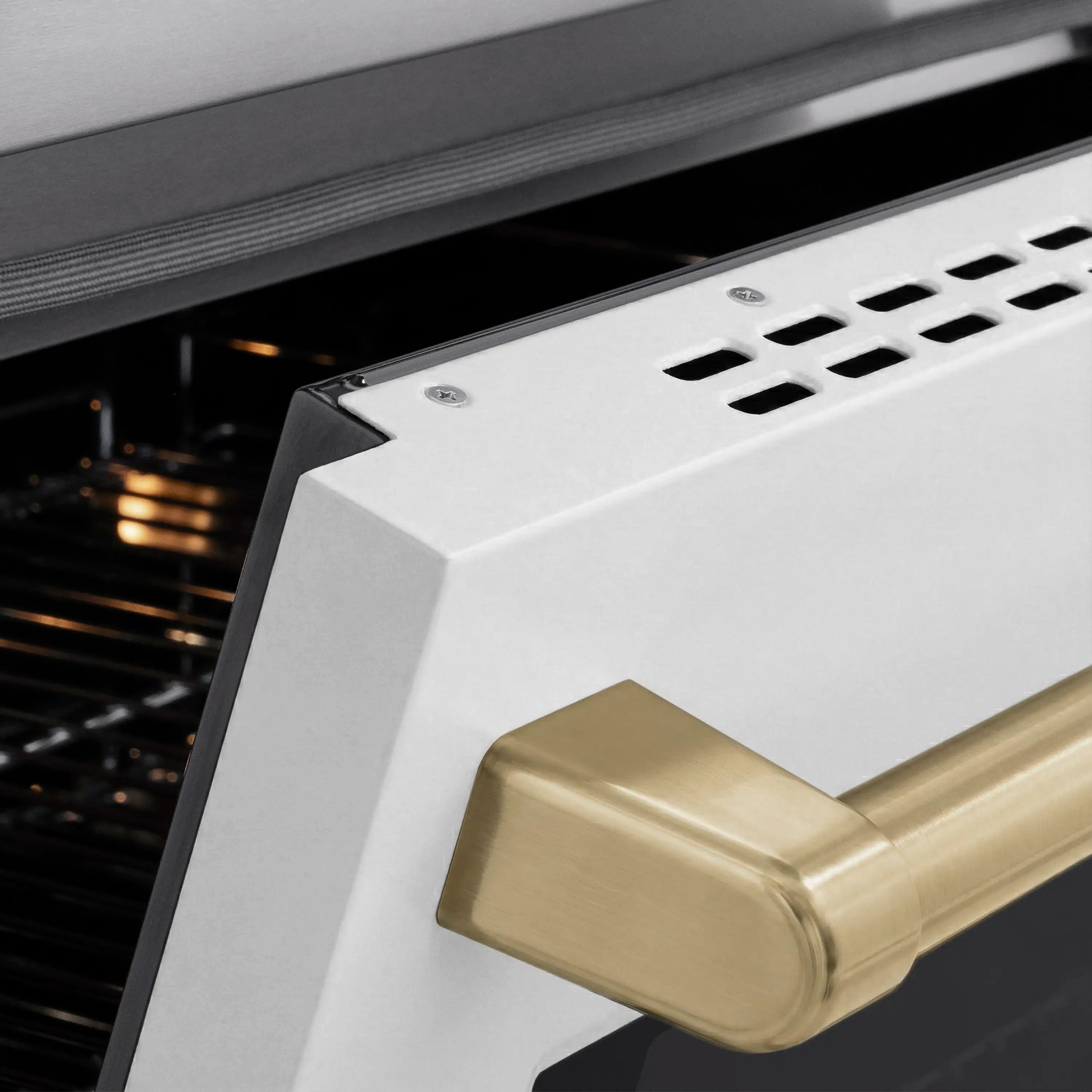 White matte oven door with champagne bronze handle above black oven interior
