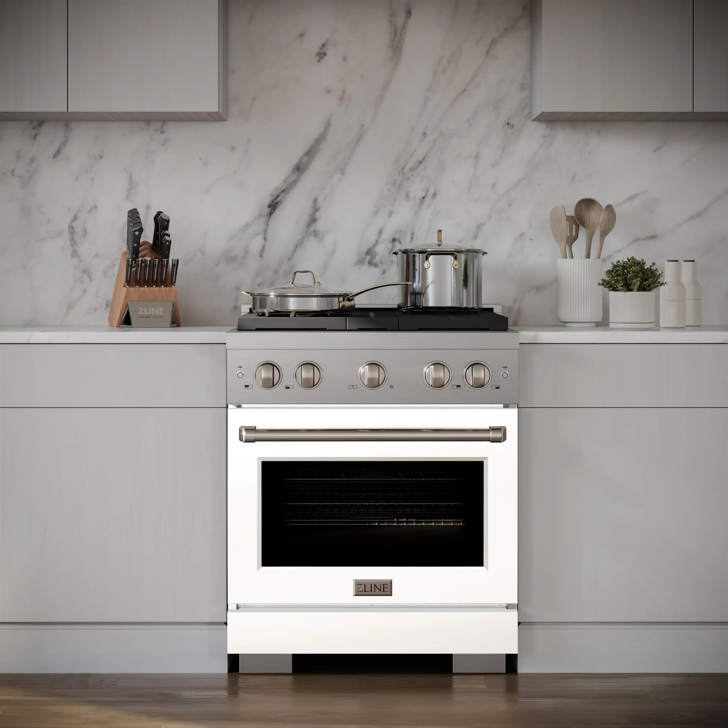 White dual fuel range with stainless handle and cookware on the 4-burner cooktop