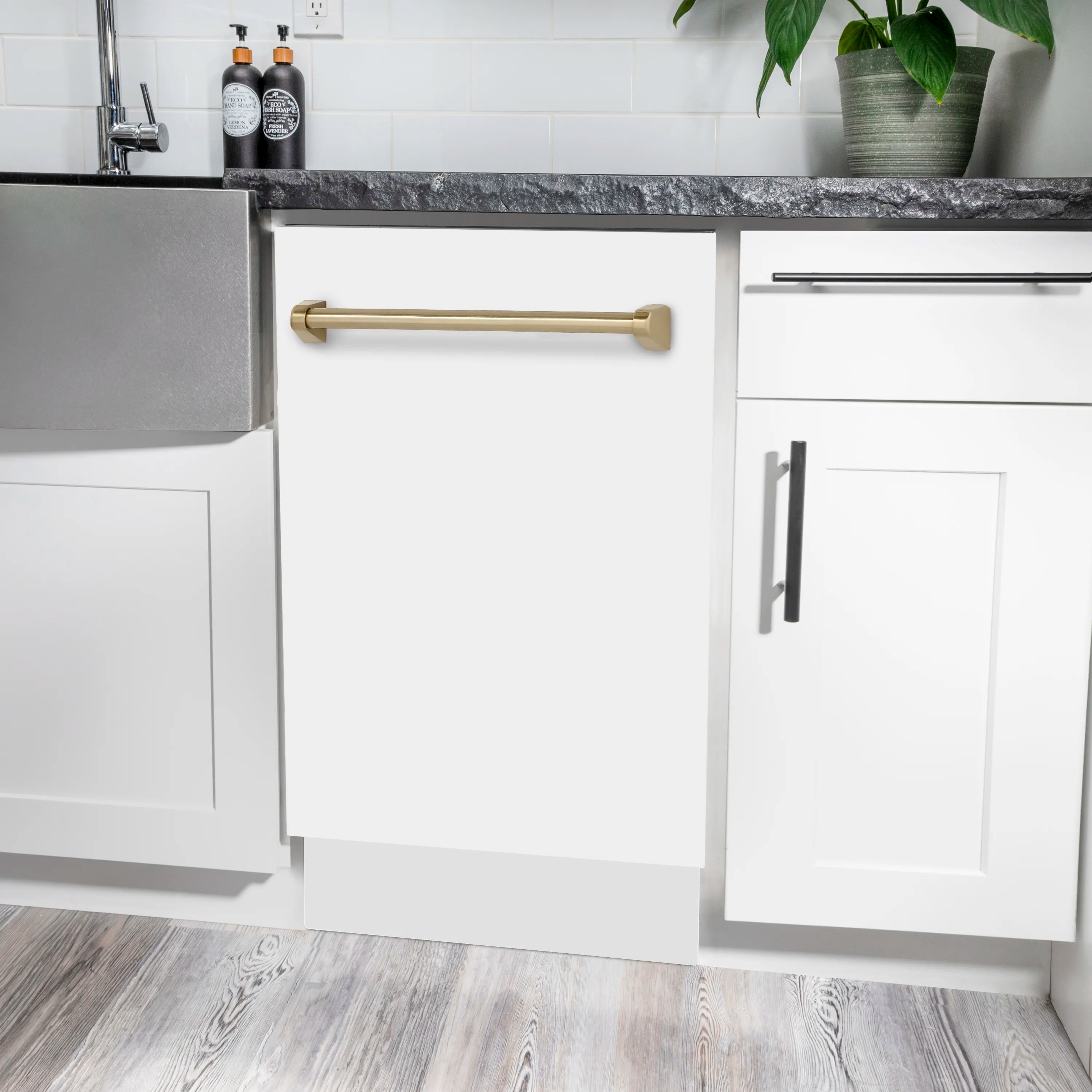 Built-in dishwasher opening with champagne bronze handle and white matte door