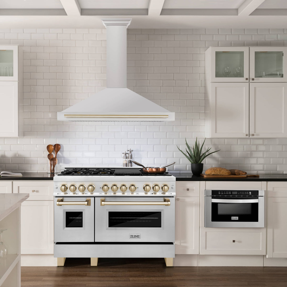 White gas range with gold-trim range hood above, stainless oven doors
