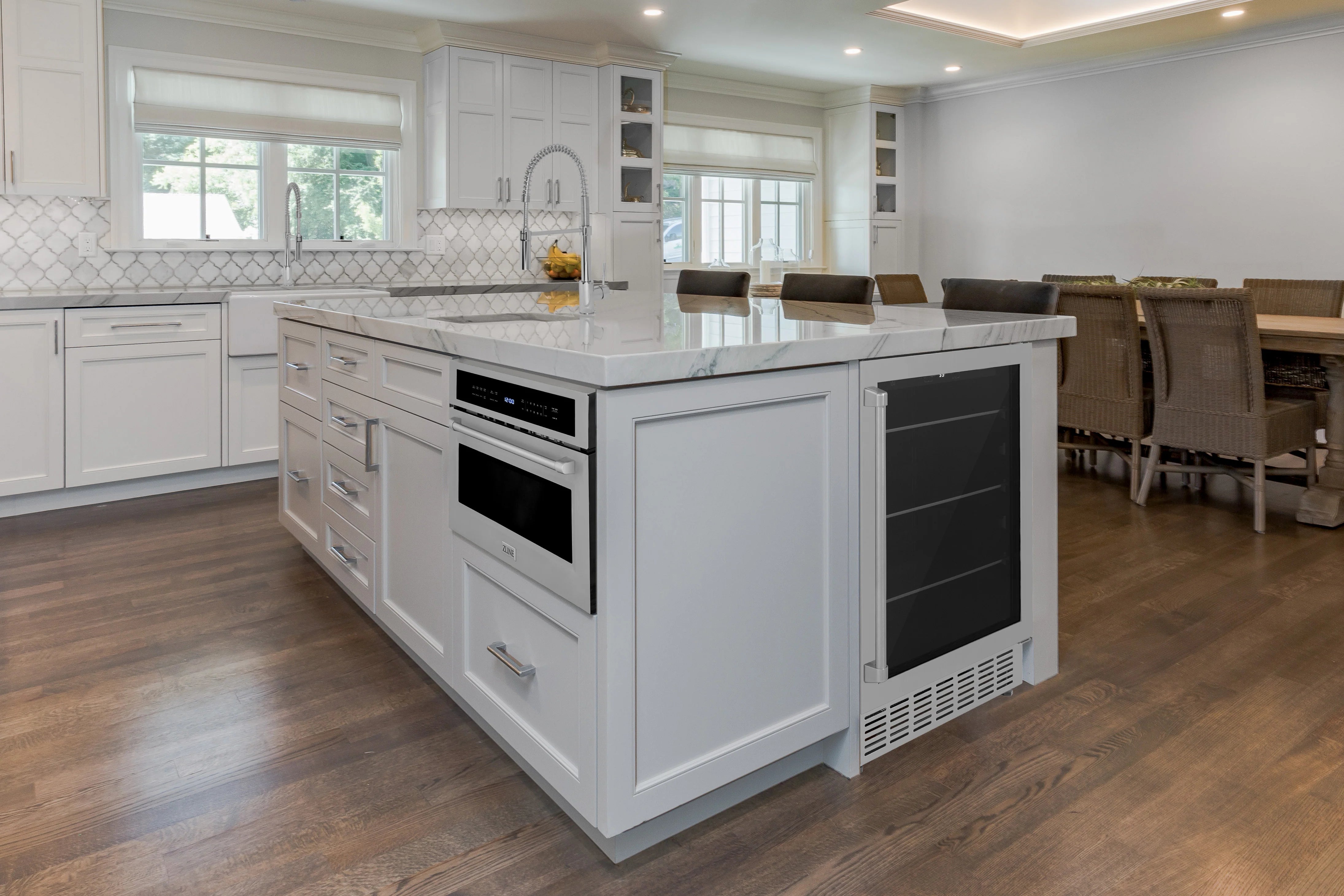 Built-in beverage fridge in kitchen island with black exterior and vented base