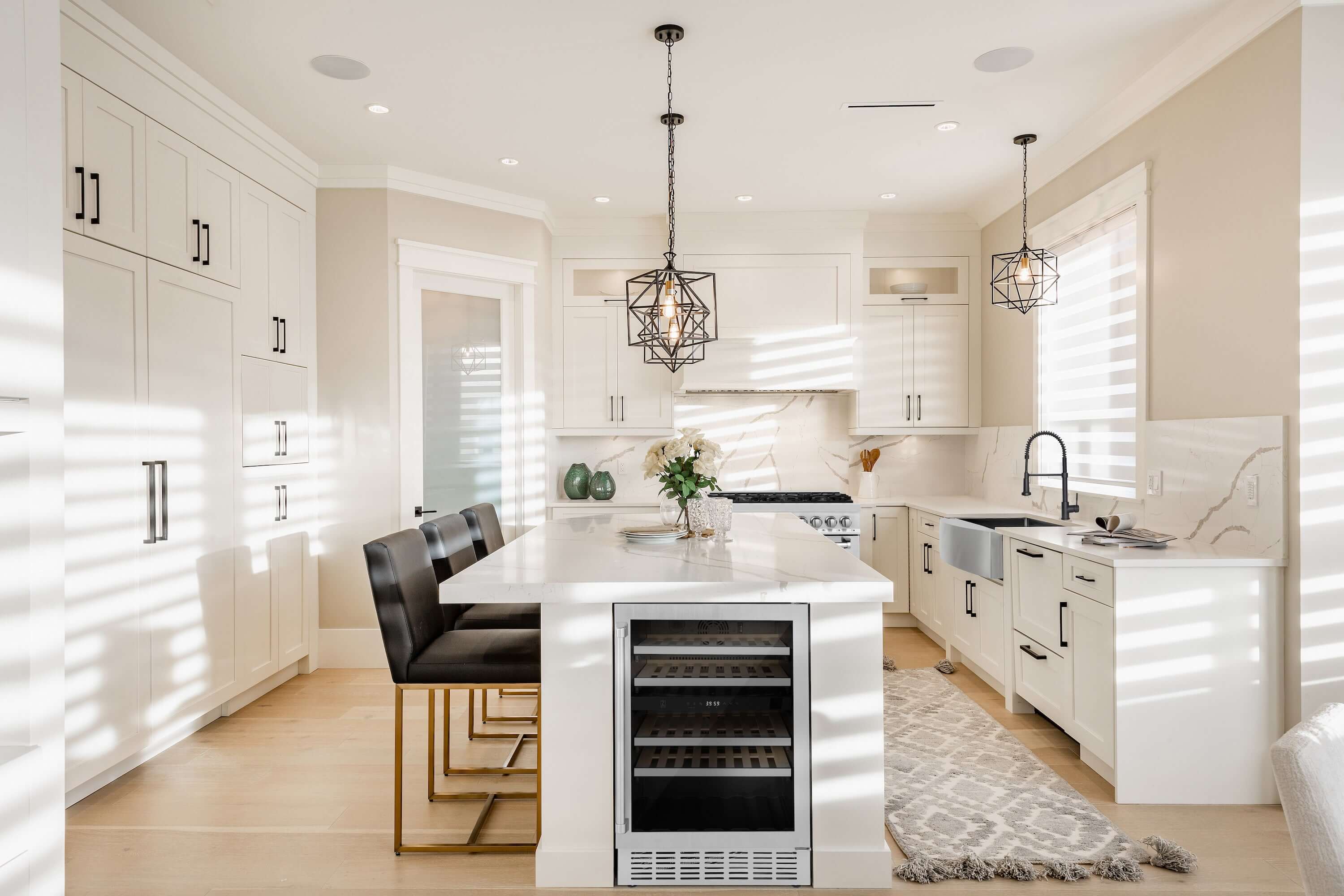 Built-in stainless wine cooler in a kitchen with open front door and bottle racks