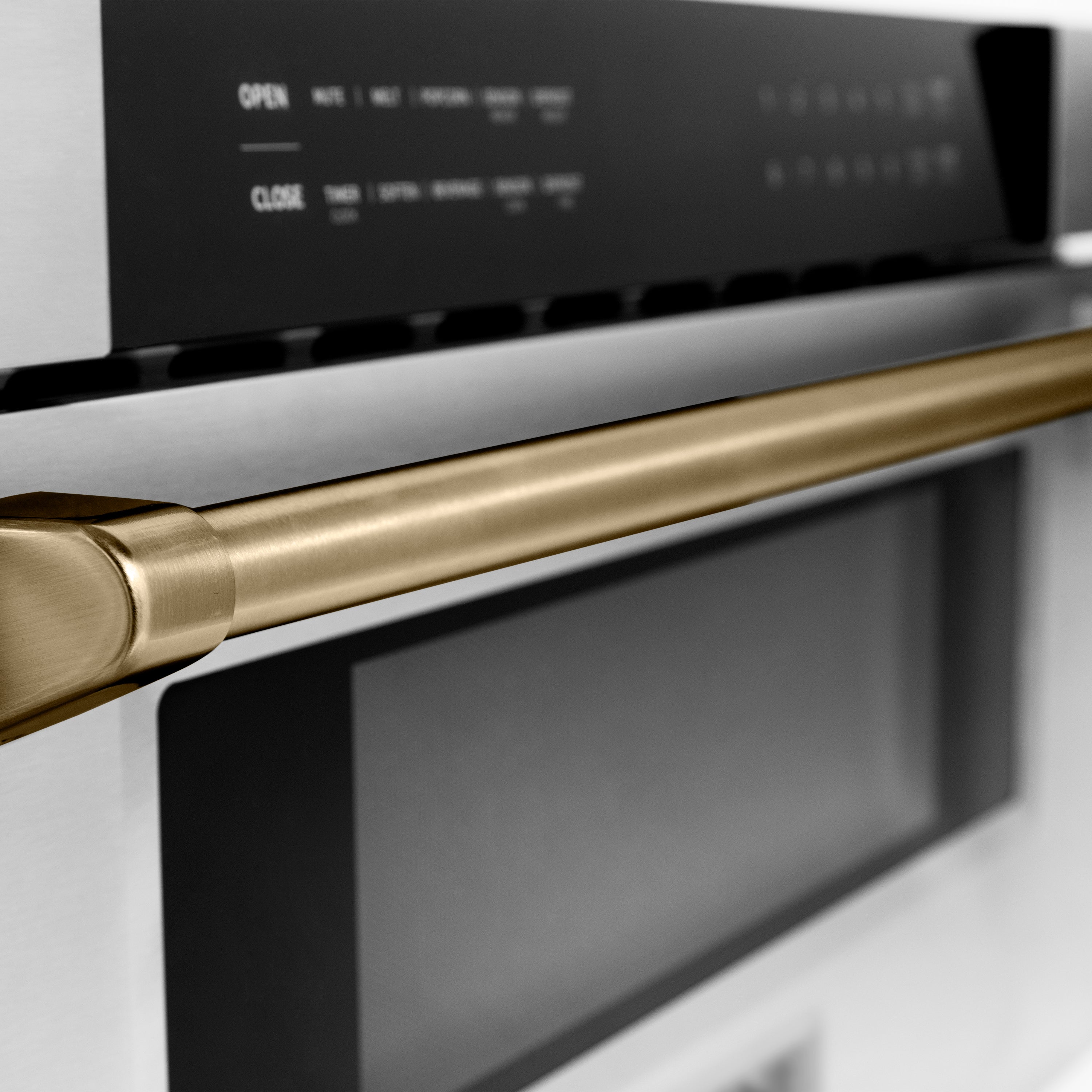 Champagne bronze microwave drawer handle above black control panel on stainless steel